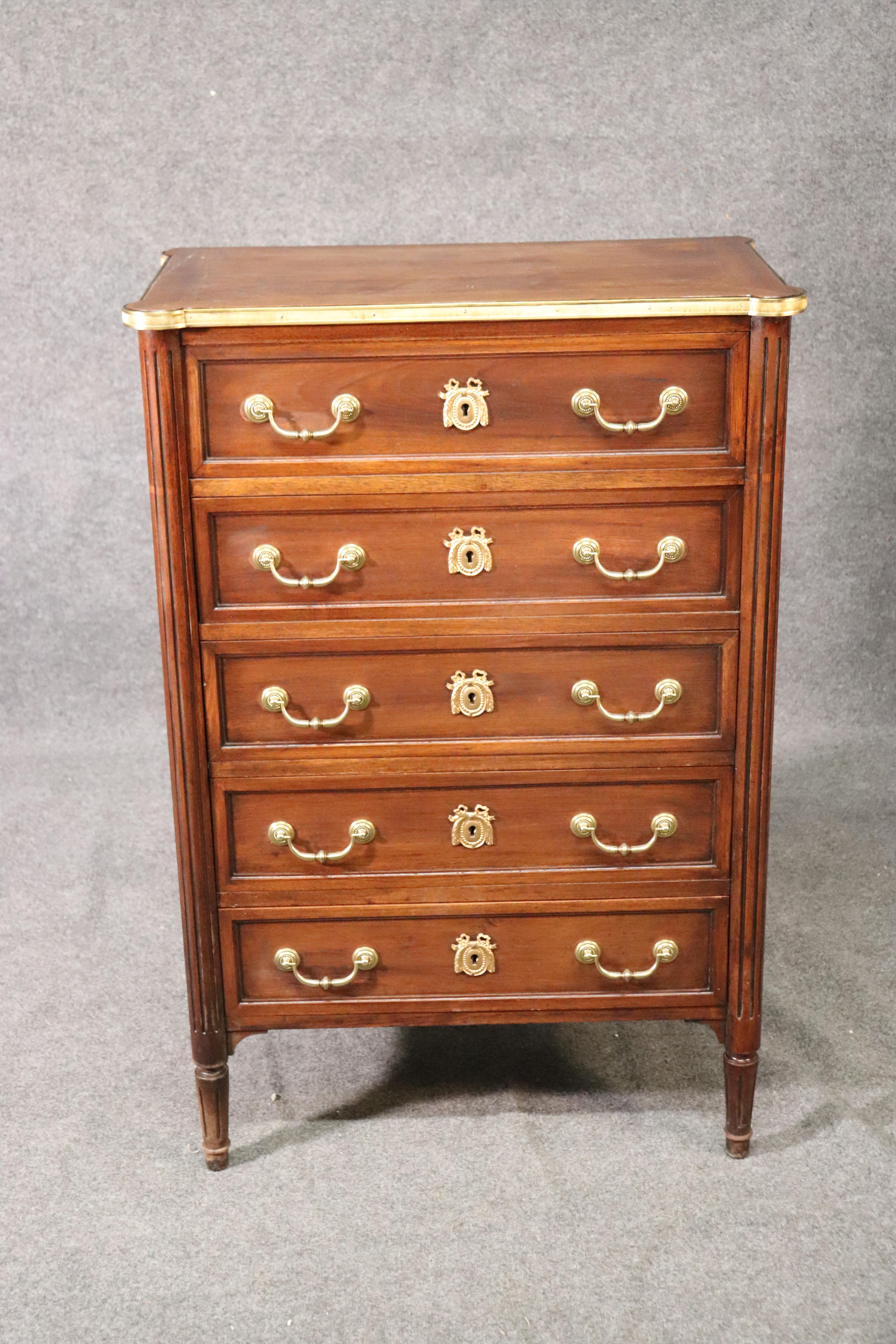 This is a fine quality Maison Jansen style brass banded dresser or lingerie chest. The piece is made of solid mahogany and has fine brass banding and brass hardware. The dresser measures 45 tall x 31 wide x 17 inches deep. The piece is in good