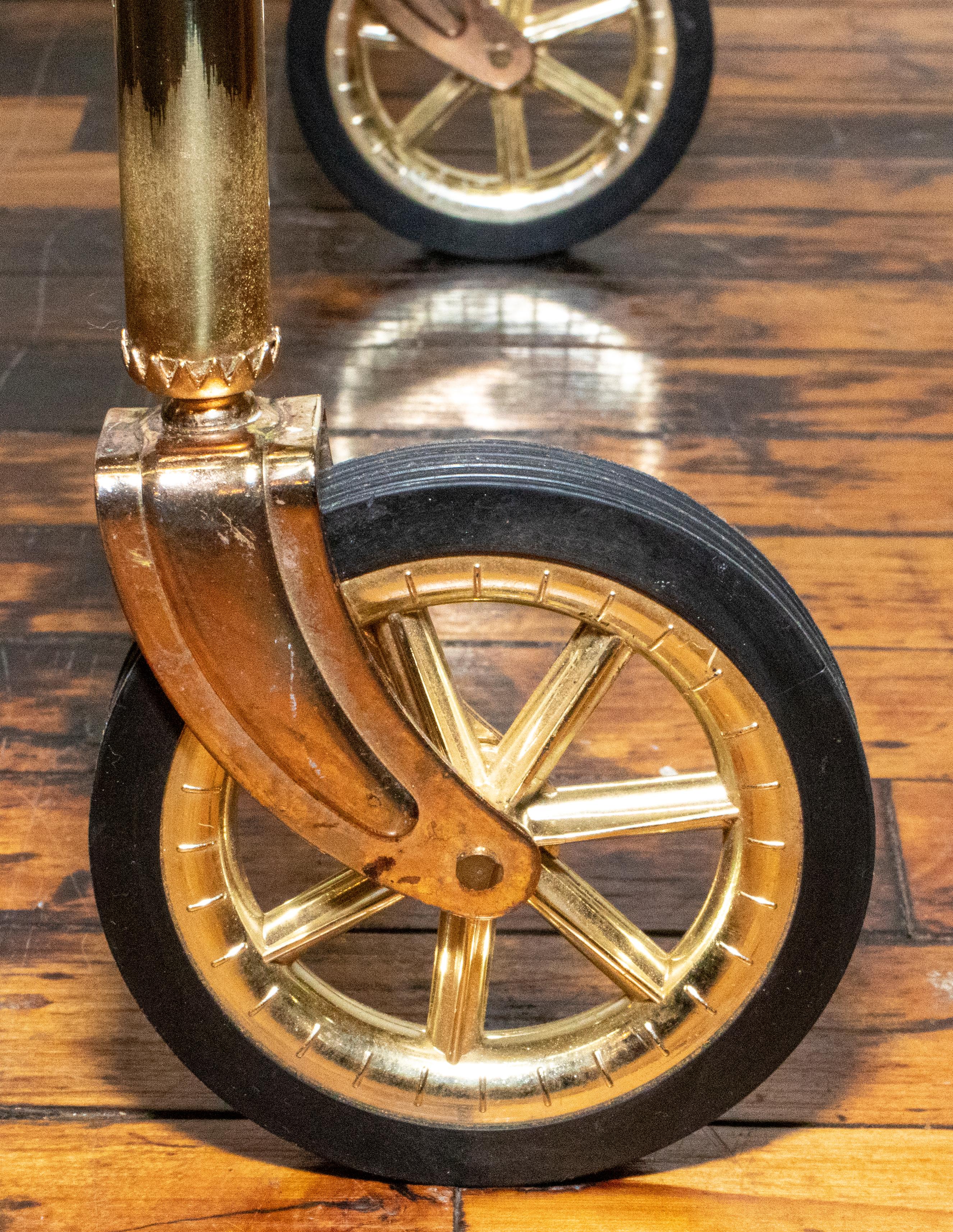 Elegant brass bar cart with 2 glass shelves. Wheels turn easily. Made in the 1970s in Italy.