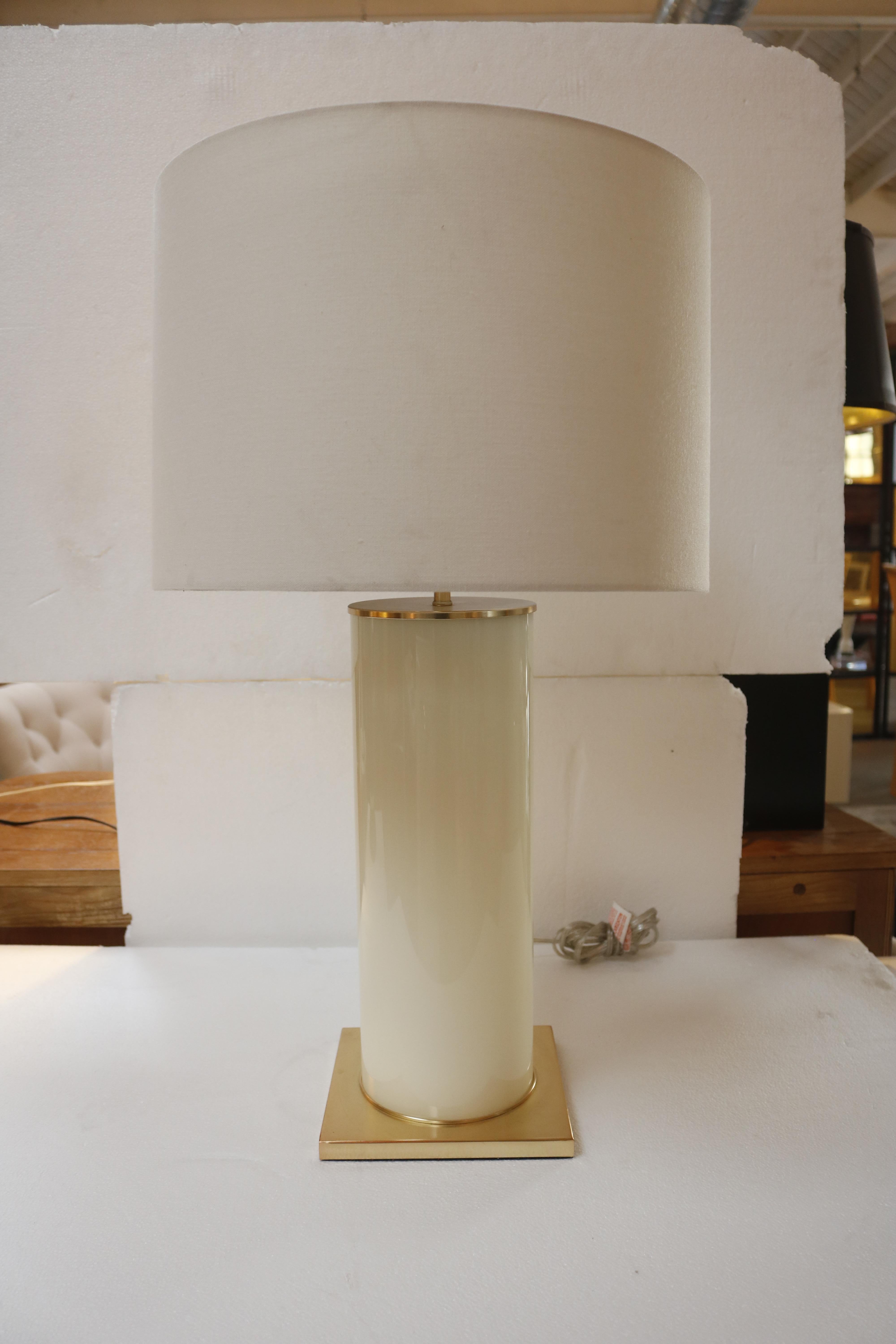 Elegant table lamp consisting of a white opaline cylinder resting on a brass, square base.
The shade is original and made of white canvas.
Measures: Without lampshade 7.5