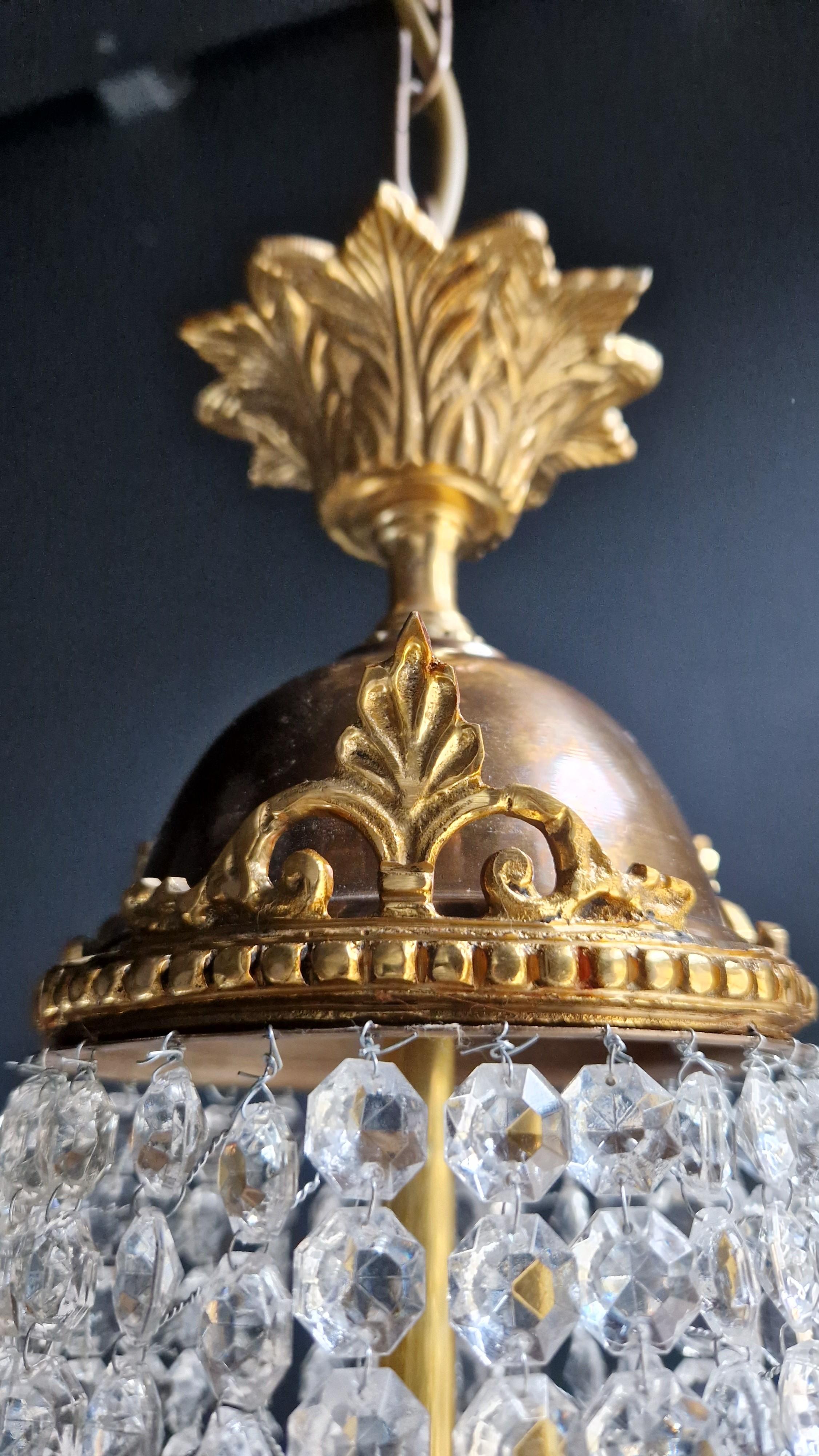 Voici un superbe lustre Empire Sac à Perles en laiton, une pièce exquise ornée de cristaux captivants, rappelant le style classique de l'ère Empire. Ce lustre antique en or a été soigneusement restauré et fabriqué par des professionnels. Il respire