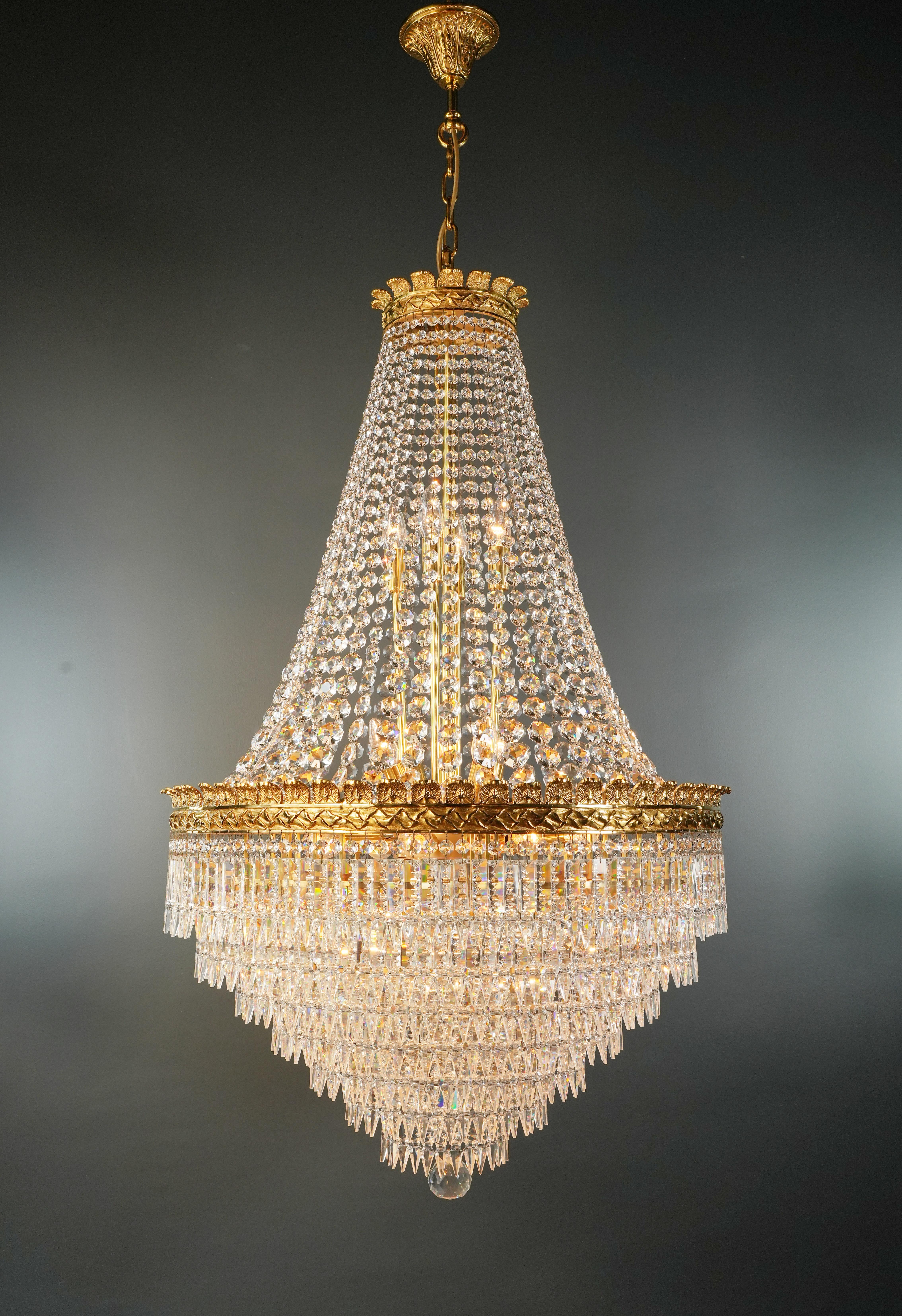 Introducing a stunning Brass Basket Empire Sac a Pearl Chandelier, an exquisite piece adorned with captivating crystals, reminiscent of the classical style of the Empire era. This is a new reproduction, and several are available, ensuring you can