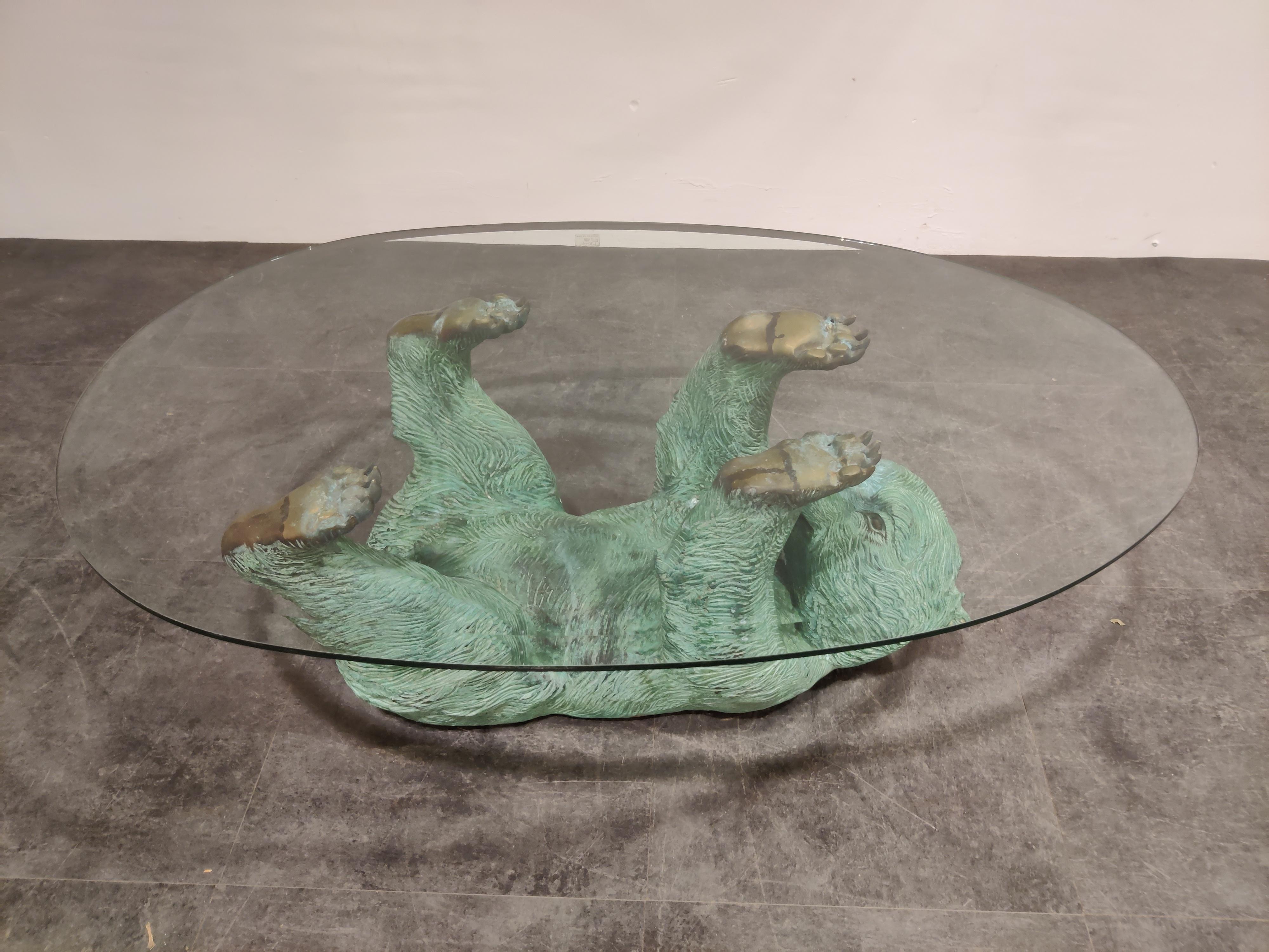 Eye-catching bronzed brass bear coffee table.

Beautiful patinated look, nicely detailed sculpture with an egg shaped/oval clear glass table top,

1970s, Belgium

Good condition

Dimensions:
Height 44cm/17.32