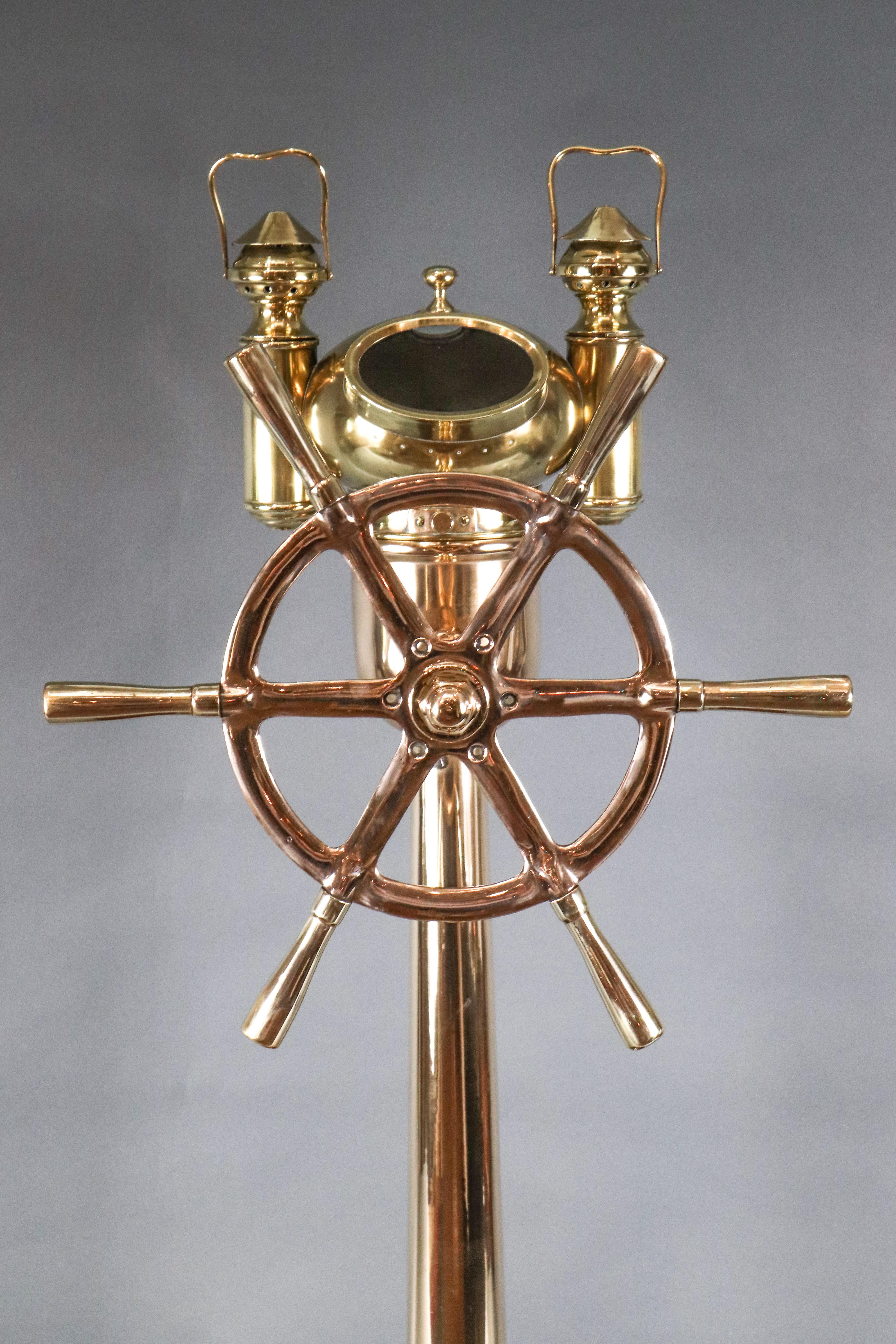 Exquisite brass binnacle with ship's wheel mounted on front.