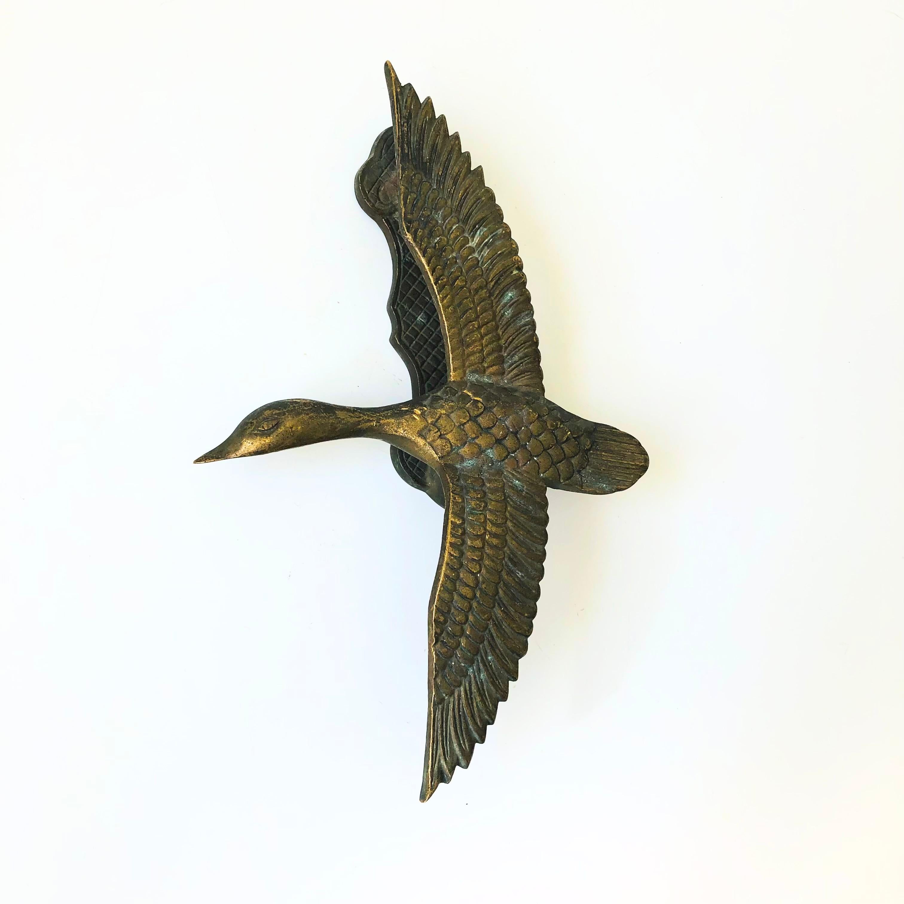 A vintage brass flying bird door knocker. Ready to hang with two holes for screws. Beautiful detailing formed into the brass. Made by Gatco.

