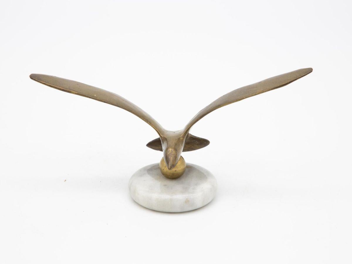 A vintage Mid-Century brass bird in flight on marble base. Wear consistent with age and use.