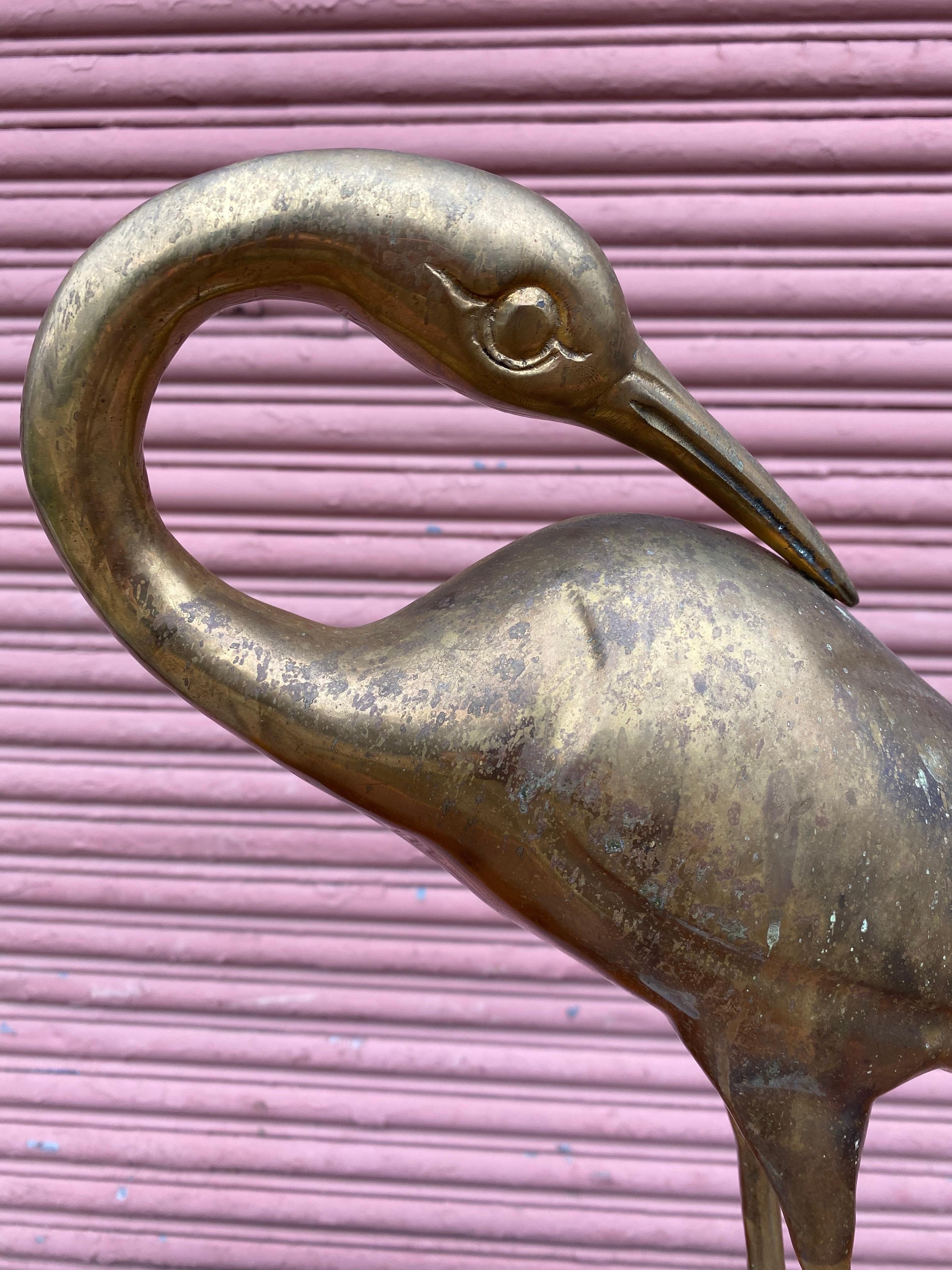 Brass bird, probably an Egret mounted on a round brass base. Nice dramatic look! Nice size and weight! Bought from a Furniture Store's Warehouse that closed in the late 1980's. Overall in nice shape, brass shows patina. Marble base is in nice shape.