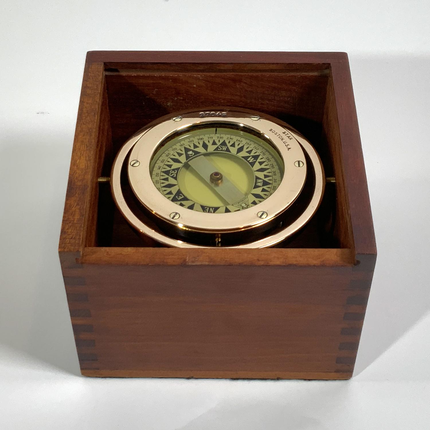 Gimballed brass boat or yacht compass by Star of Boston. Bezel is pierced with number 27645. Beautiful polish job on the brass. Fitted to a varnished wood box with sliding lid. Circa 1940. Perfect display piece. Great gift.