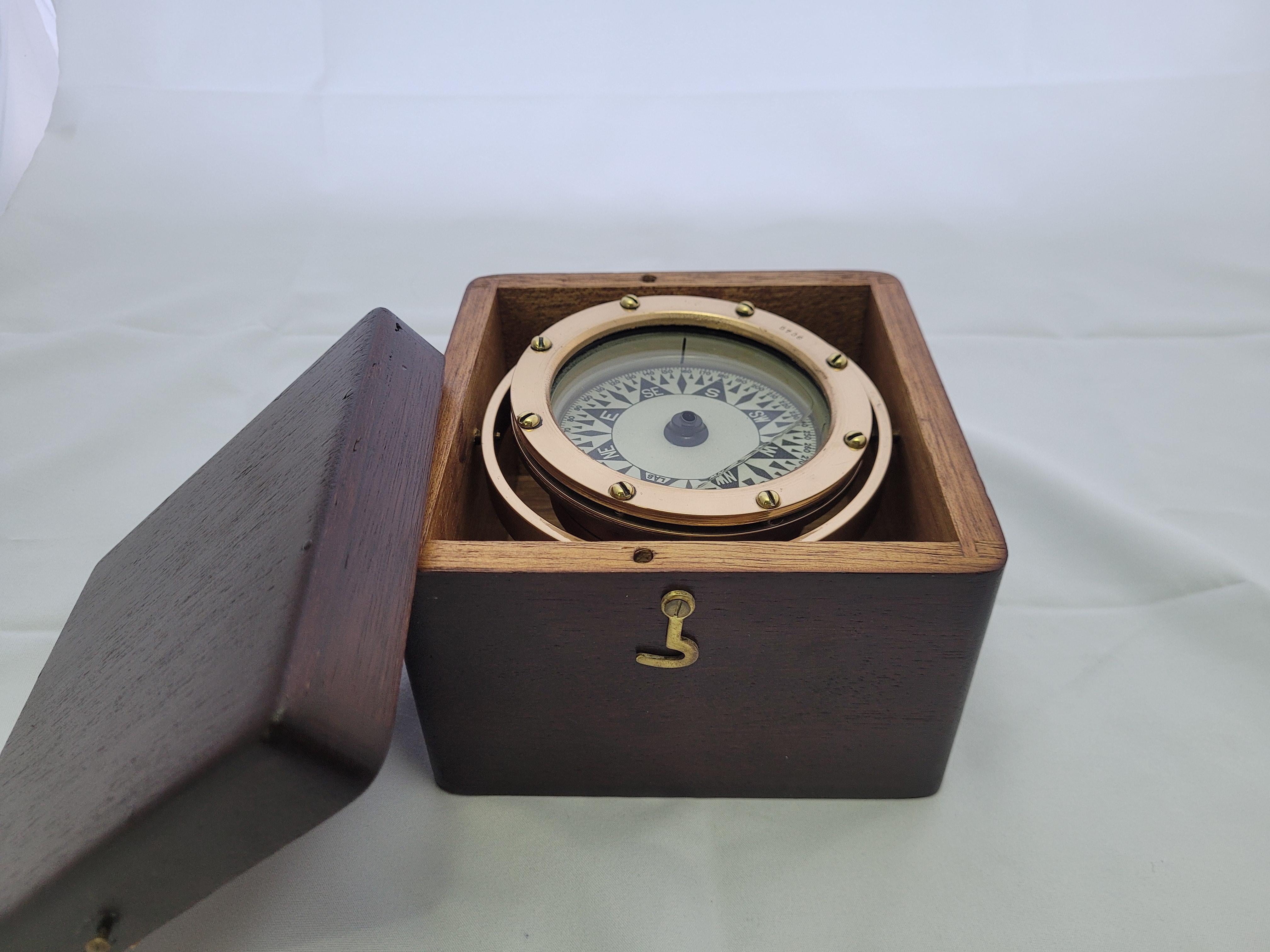 Classic early twentieth century boat compass. The gimballed compass has been meticulously polished and lacquered. This classic marine instrument is fitted to its original hardwood box with a fine varnished finish. The box has a fitted lid with brass
