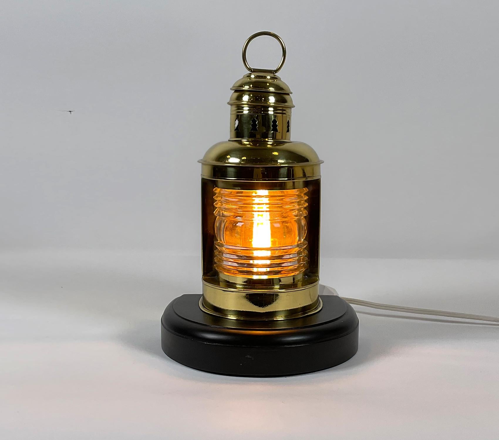 Solid brass ship or boat bow lantern by Perkins Marine Lamp Corporation of Brooklyn, New York. With Fresnel lens, vented top and carry ring. Mounted to a mahogany base. This marine lantern has been rewired with a new socket for home use.

Weight: 4