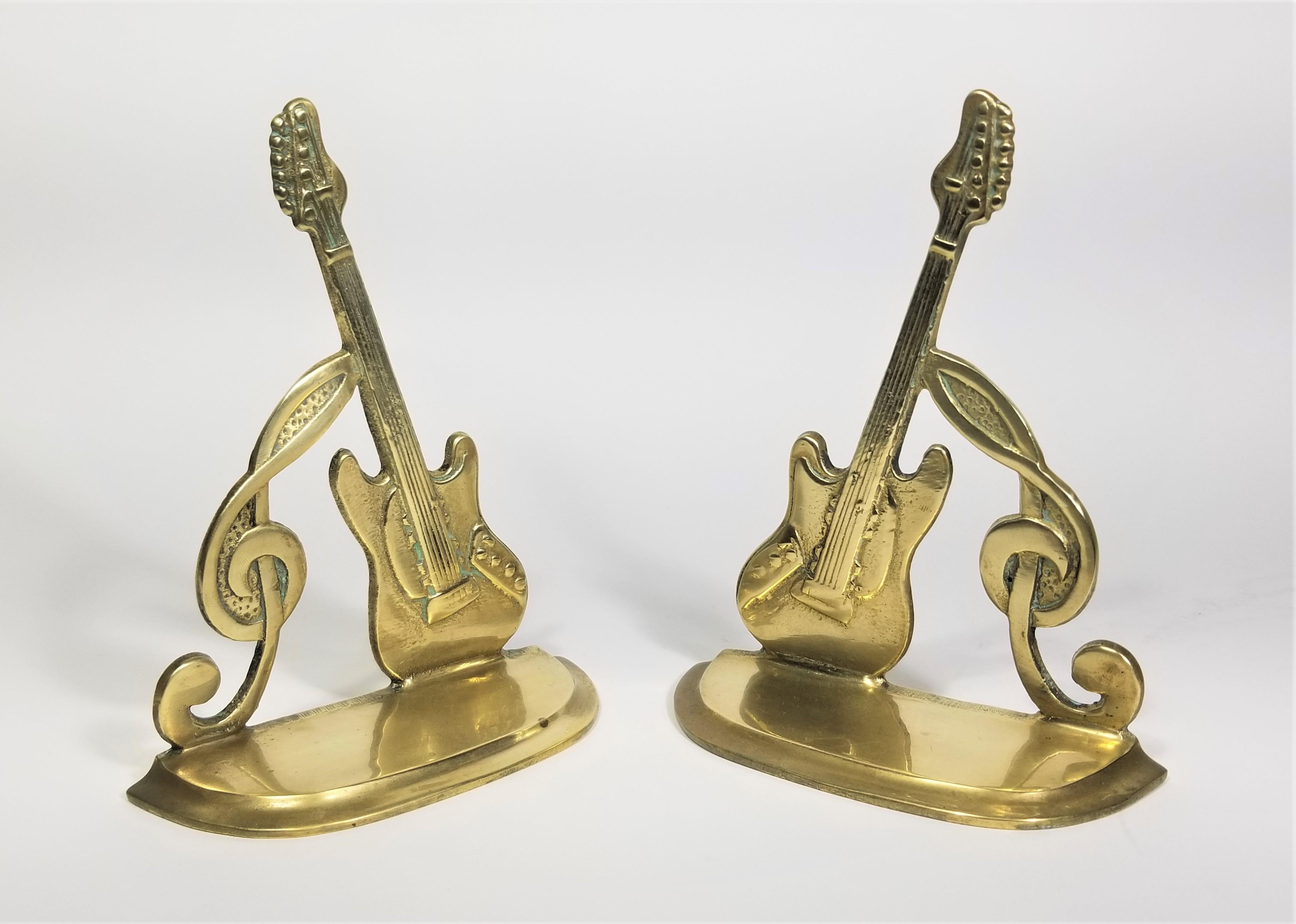 Pair of brass bookends guitar and music note dated 1987.