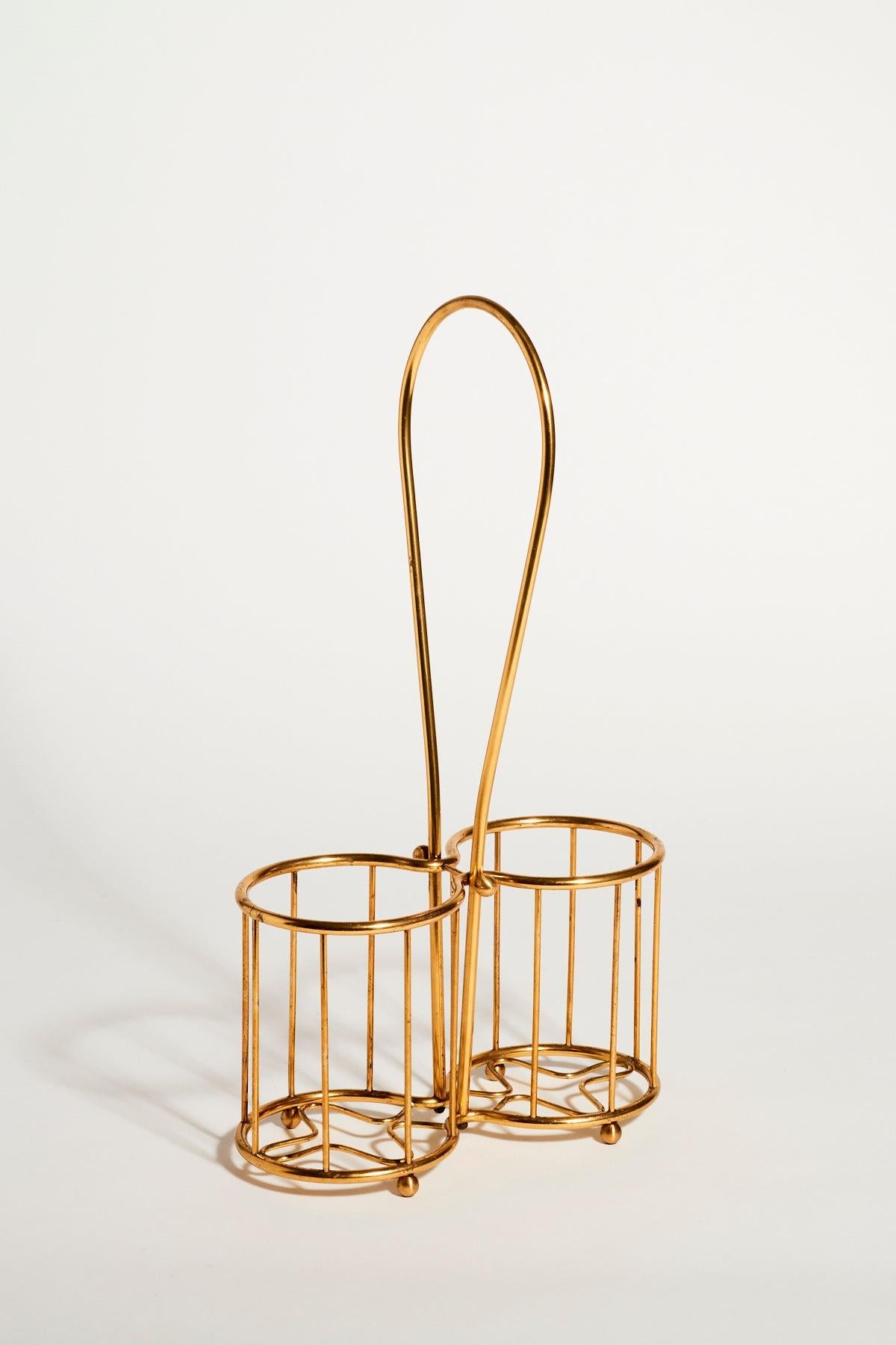 1970s brass twin bottle holder in a basket style with ball feet and a looped handle.