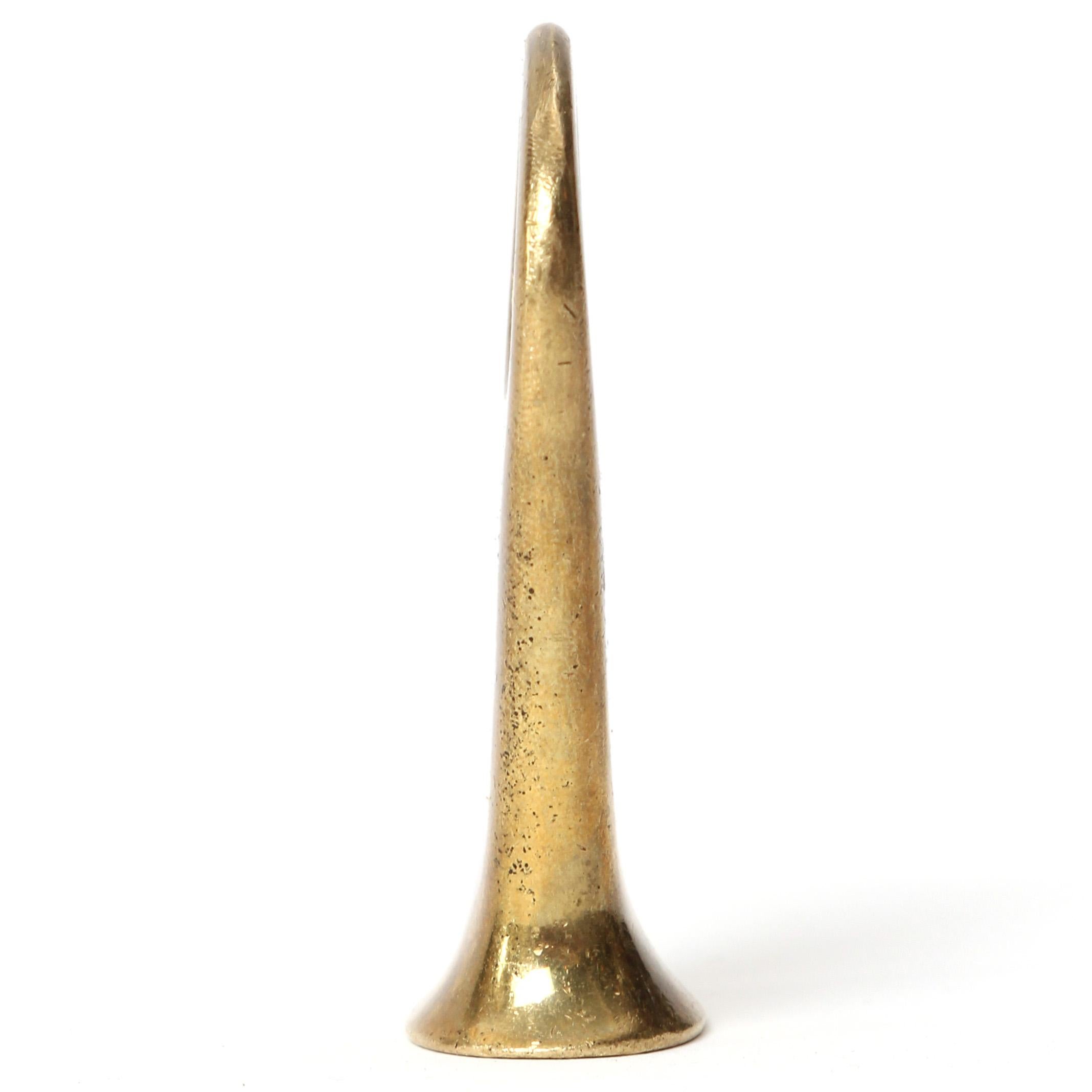 A finely modeled and well-patinated Mid-Century Modern brass bottle opener having a flattened end enabling it to stand. Designed and manufactured by Carl Aubock in Austria, 1950s.