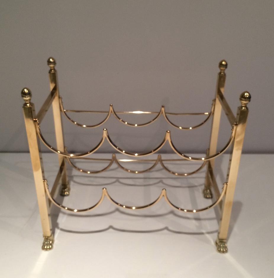 Dieser Flaschenhalter ist aus Messing gefertigt. Es handelt sich um ein sehr geradliniges und einfaches Design mit Klauenfüßen und Endstücken, das 6 Flaschen aufnehmen kann. Dies ist ein französisches Werk von Maison Jansen. CIRCA 1940