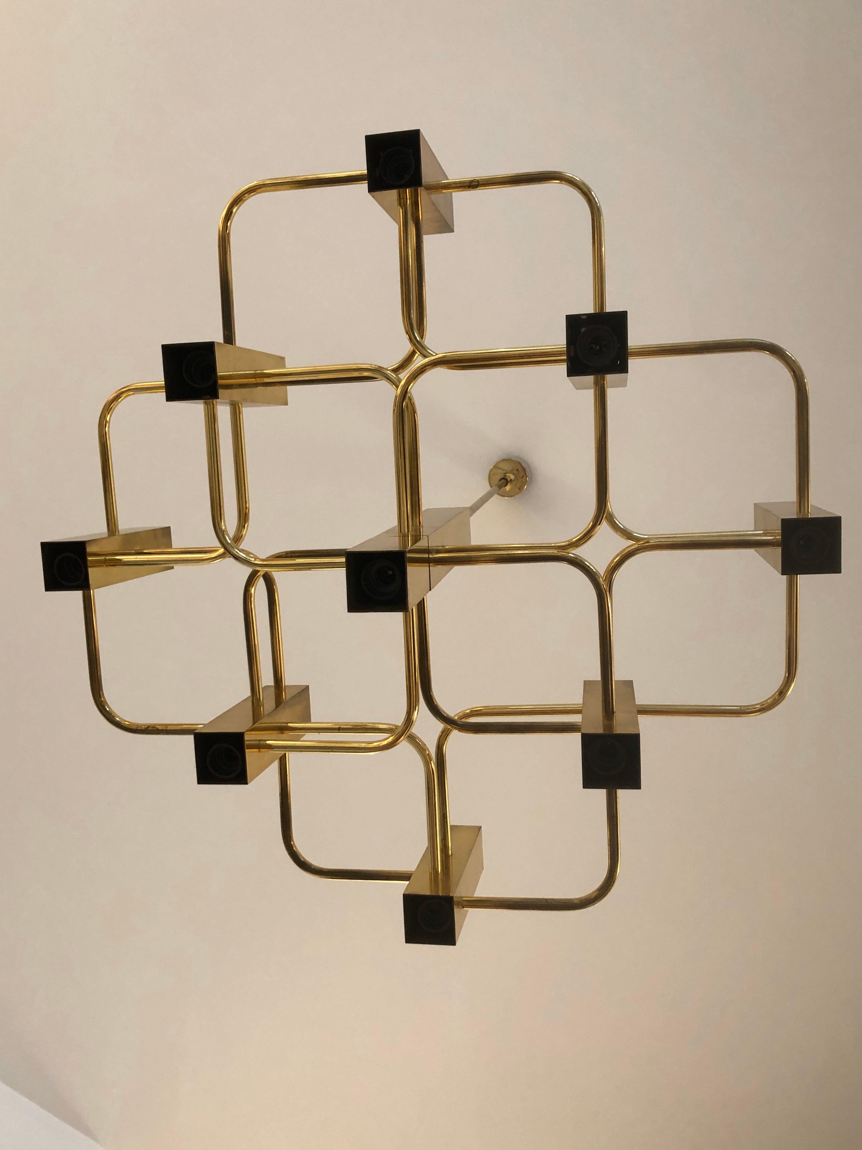 A stunning modernist chandelier Boulanger chandelier designed by Gaetano Sciolari in brass with 9 brass cubes lights surrounding a center support that form a geometrical pattern. 
Each light fitting can be pushed inside its frame to suit different