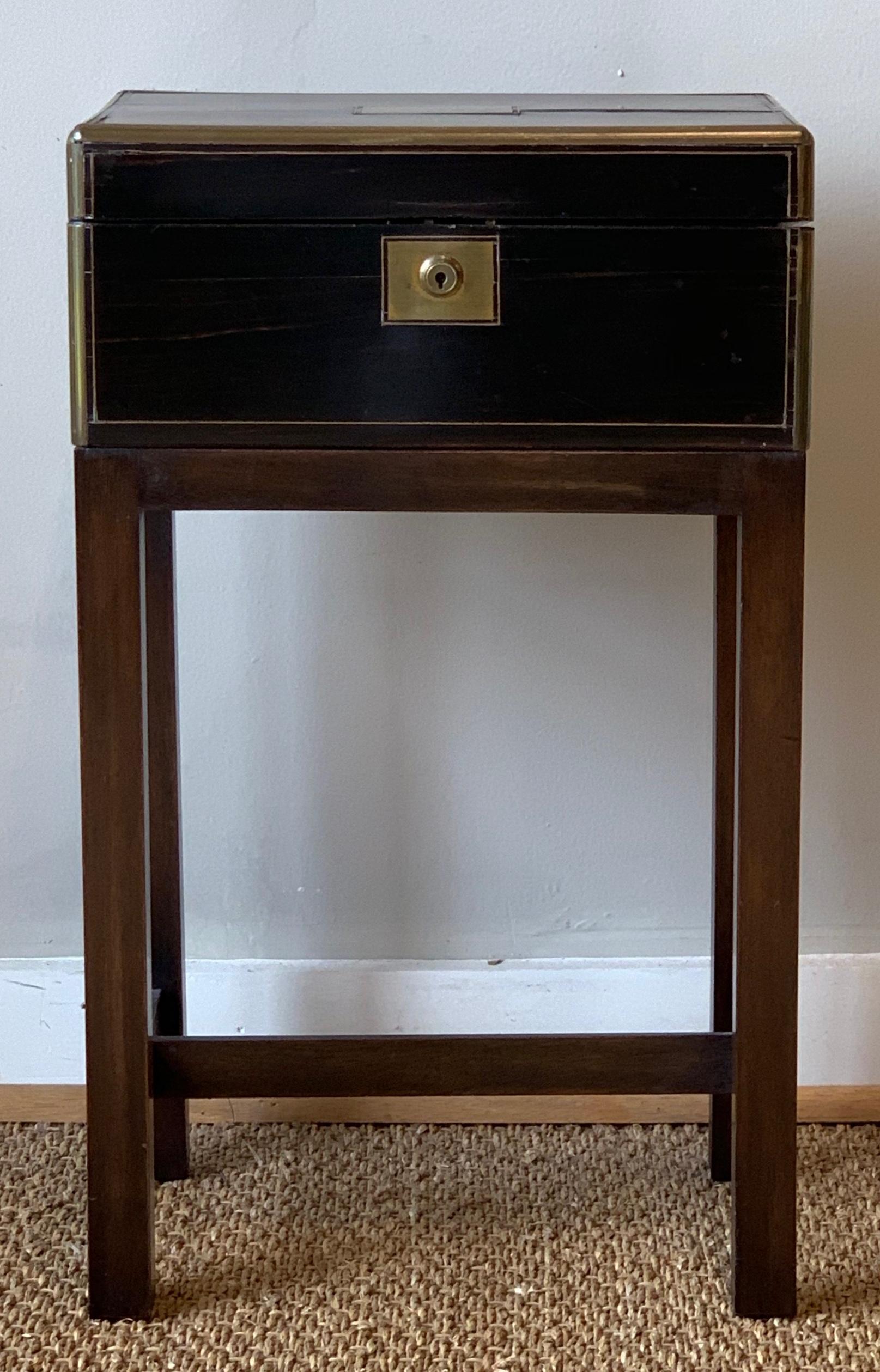 A lovely mid-19th century English Macassar wood and brass writing box fitted with its original fold-out leather writing surface and ink wells on later custom made stand to function as a side table.