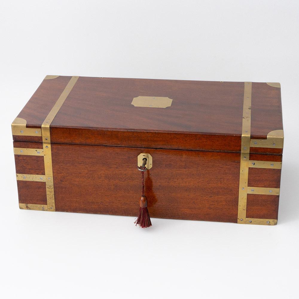 Heading : Brass bound writing slope from the mid 19th century

Date : c1850

Period : Victoria

Origin : England

Decoration : Brass bound with vacant brass cartouche. Inteiror lined with black leather – two inkwells included – pen tray and cavity