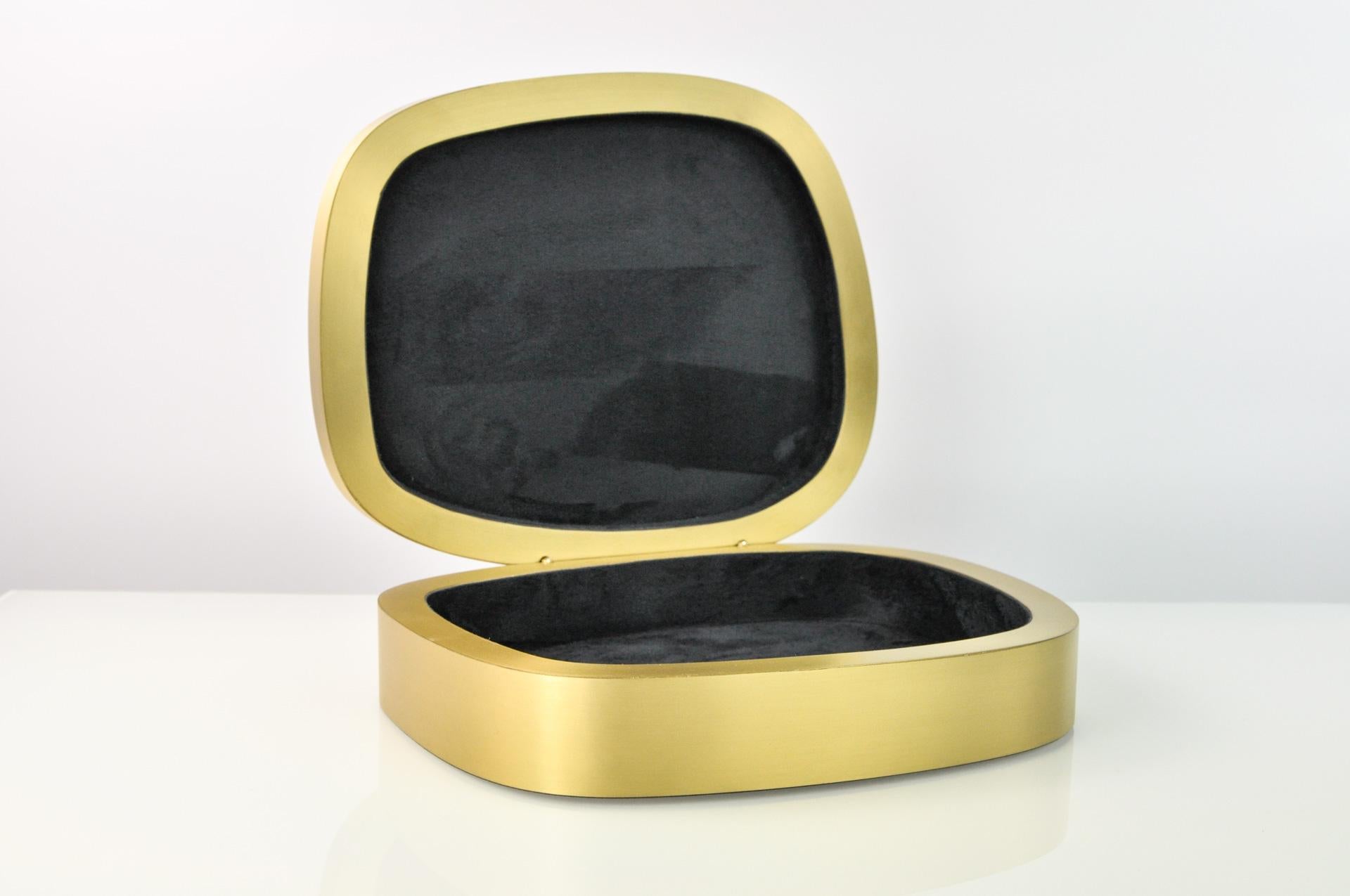This box is handcrafted of brushed brass with a white rock crystal lid.

It is hinged and the interior is lined with a high quality black microsuede.

The dimensions of this piece are 10,8