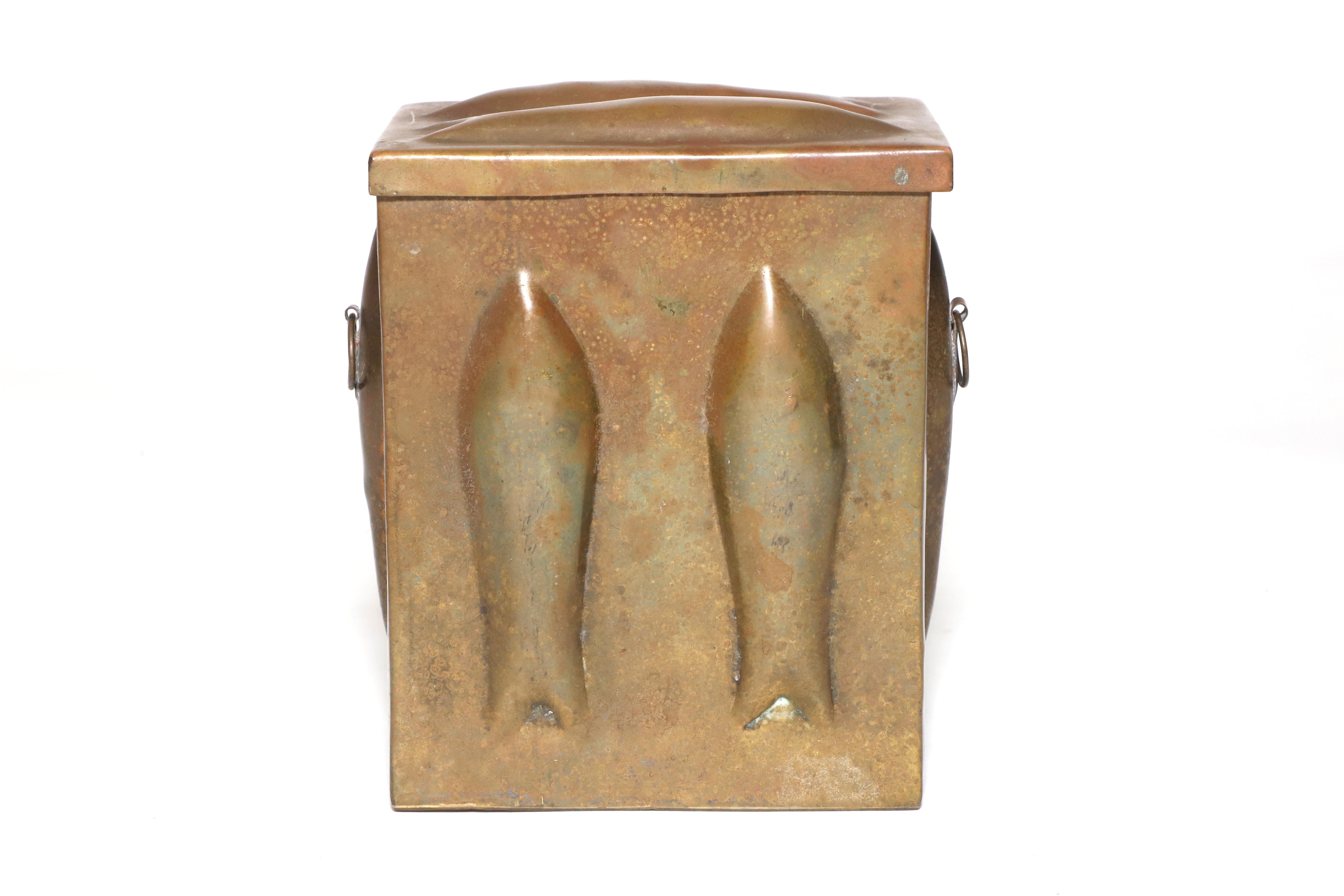 Decorative brass box made by Saks Fifth Avenua, India. Embossed with fish silhouttes on each face with two small brass circular handles on each side. Natural patina. 

Property from esteemed interior designer Juan Montoya. Juan Montoya is one of