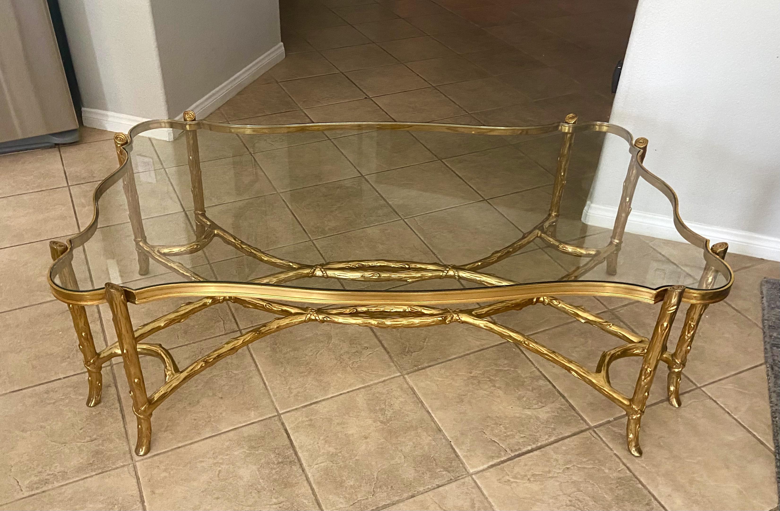 Large one of a kind cast brass (or bronze) intertwining tree branches coffee table. The table is serpentine shape with an intricately cut inset glass top. The table is very heavy and solid with quality workmanship throughout. To our knowledge there