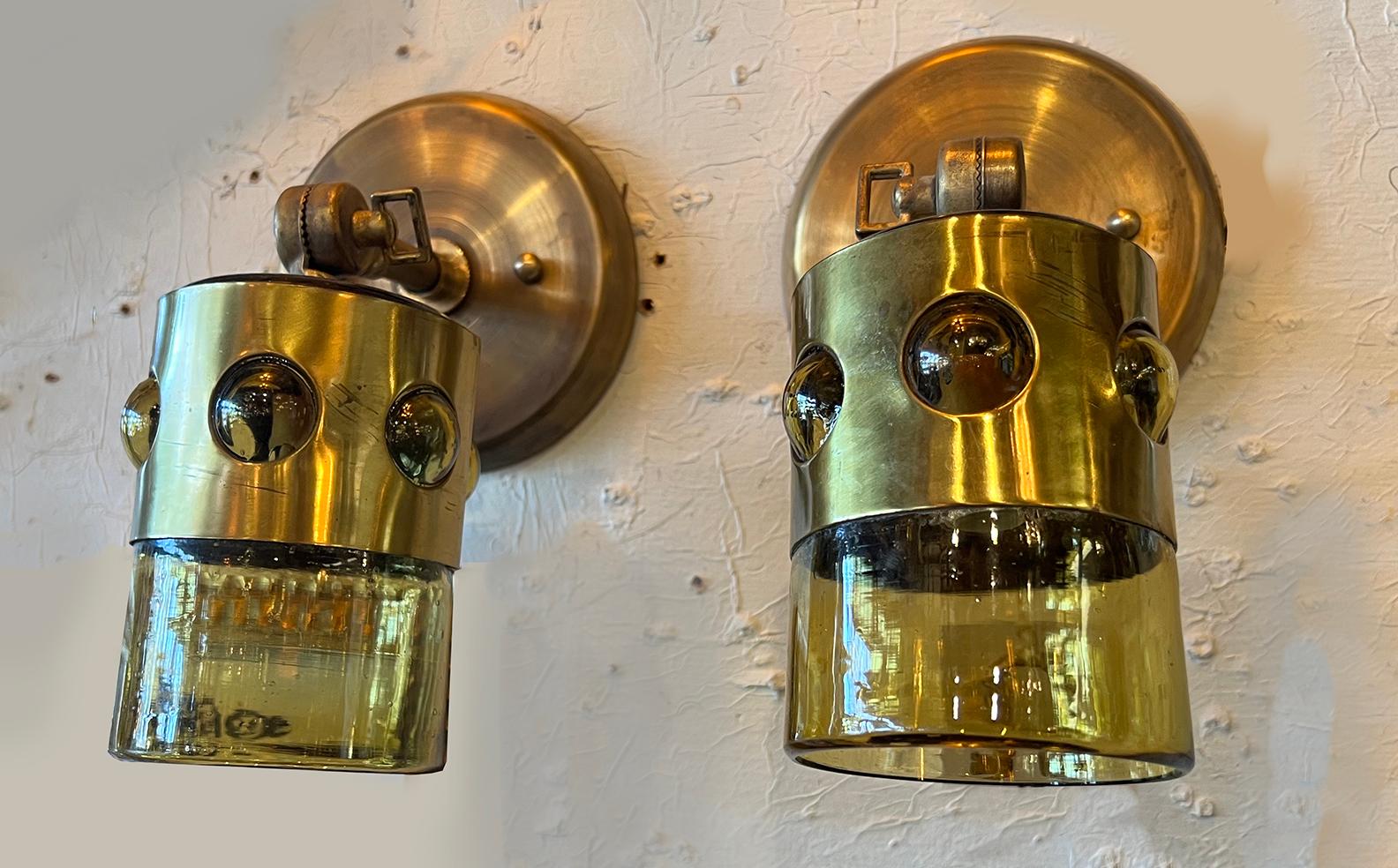 Visually stunning pair of Felipe Derflingher Brutalist Caged Glass Imprisoned Glassware made into adjustable brass wall sconces. Just loosen key, aim up or dow, tighten and there you go. Created from truly old, 60's blown drinking glasses, the rest