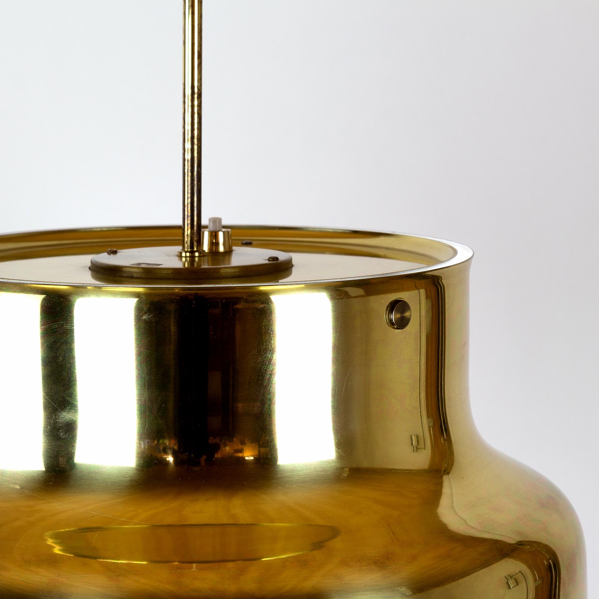 An early large Bumling pendant in brass designed by Anders Pehrson in 1968 for Ateljé Lyktan, Sweden. Double bulb holder and acrylic light diffuser.

 