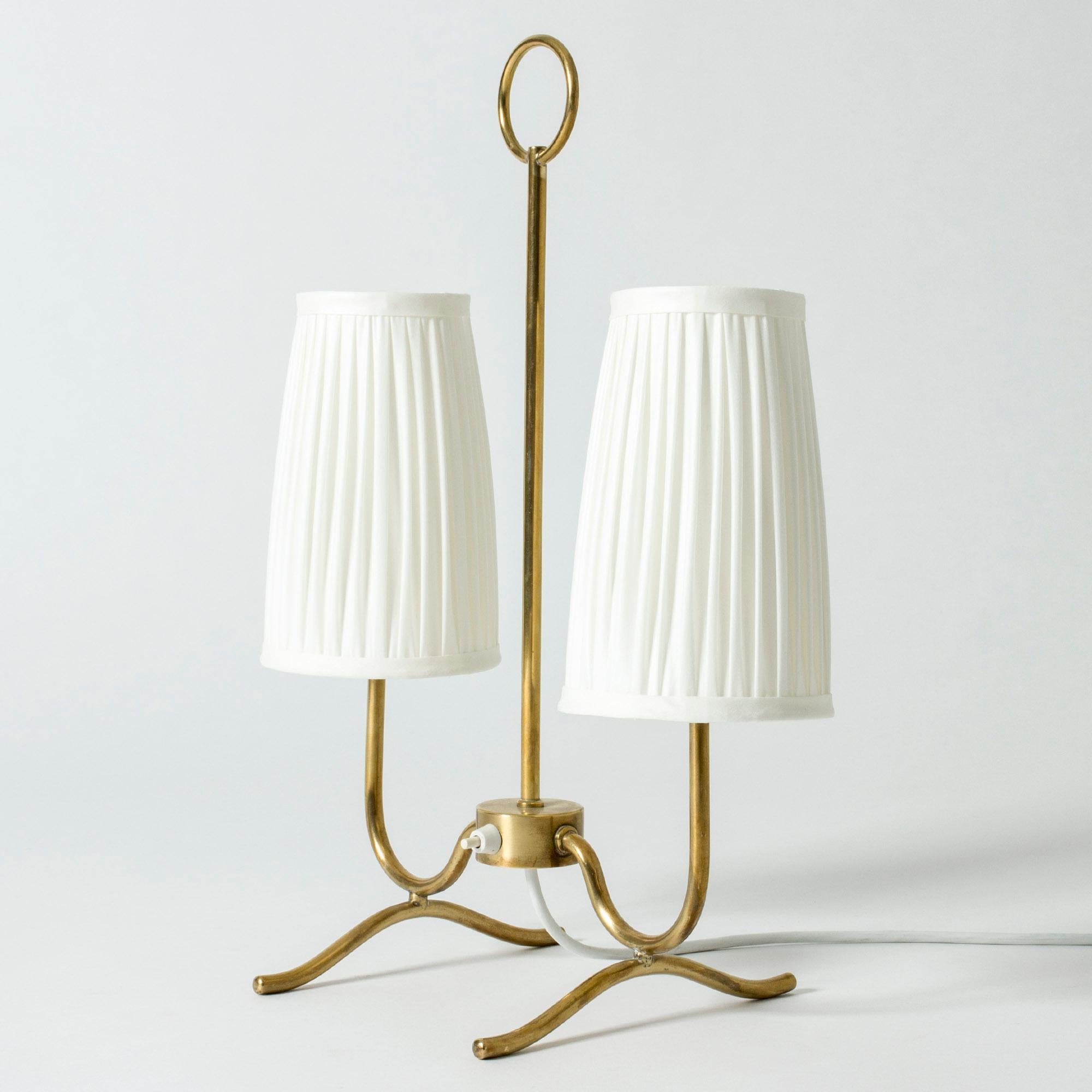 Lovely midcentury table lamp, made from brass. Slender, elegant design with two shades and a decorative hoop in the middle.