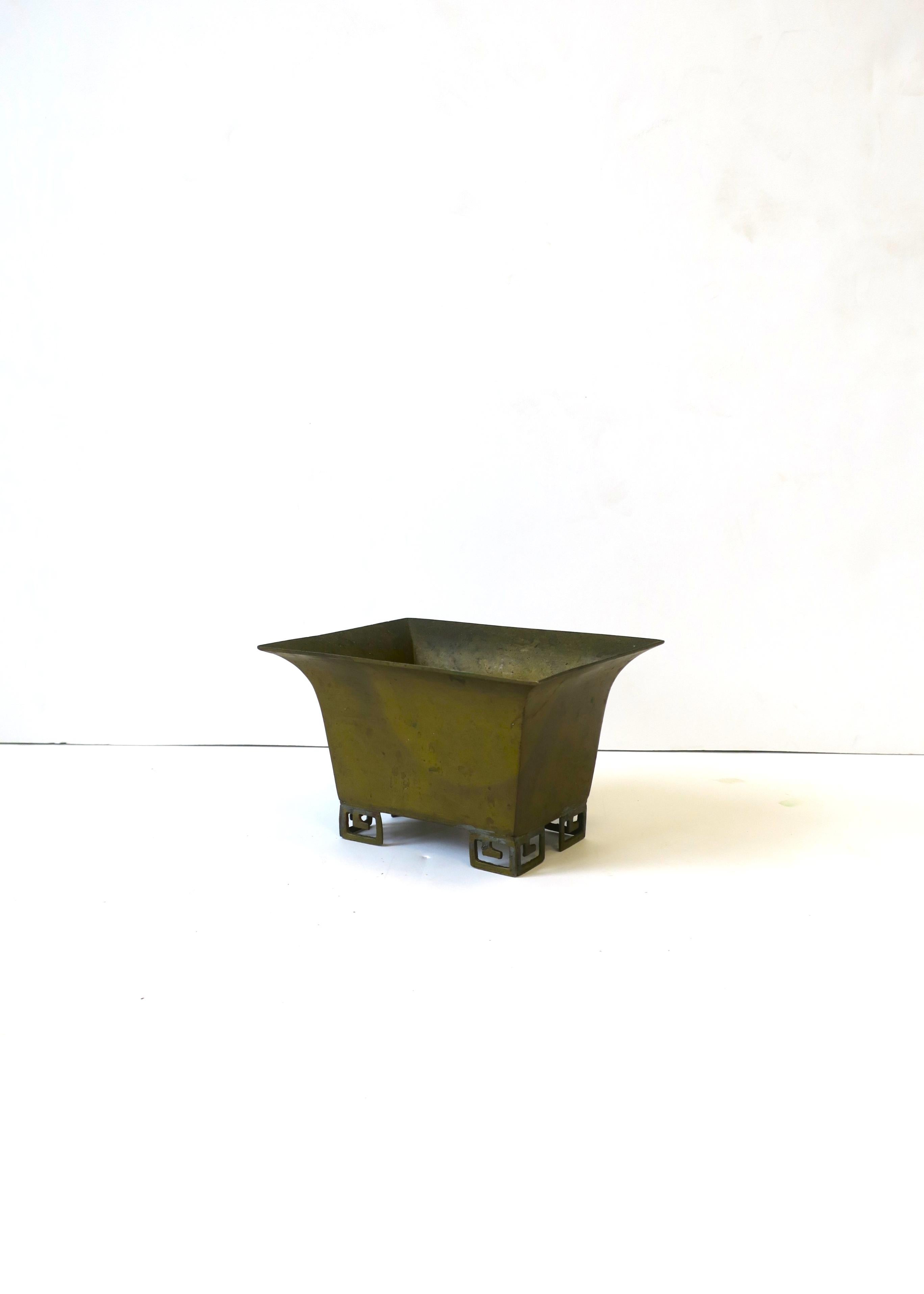 A small, rectangular, brass cachepot or jardiniere in the Chinoiserie style, ca. 1970s. Shown holding succulent plant. Dimensions: 4.5