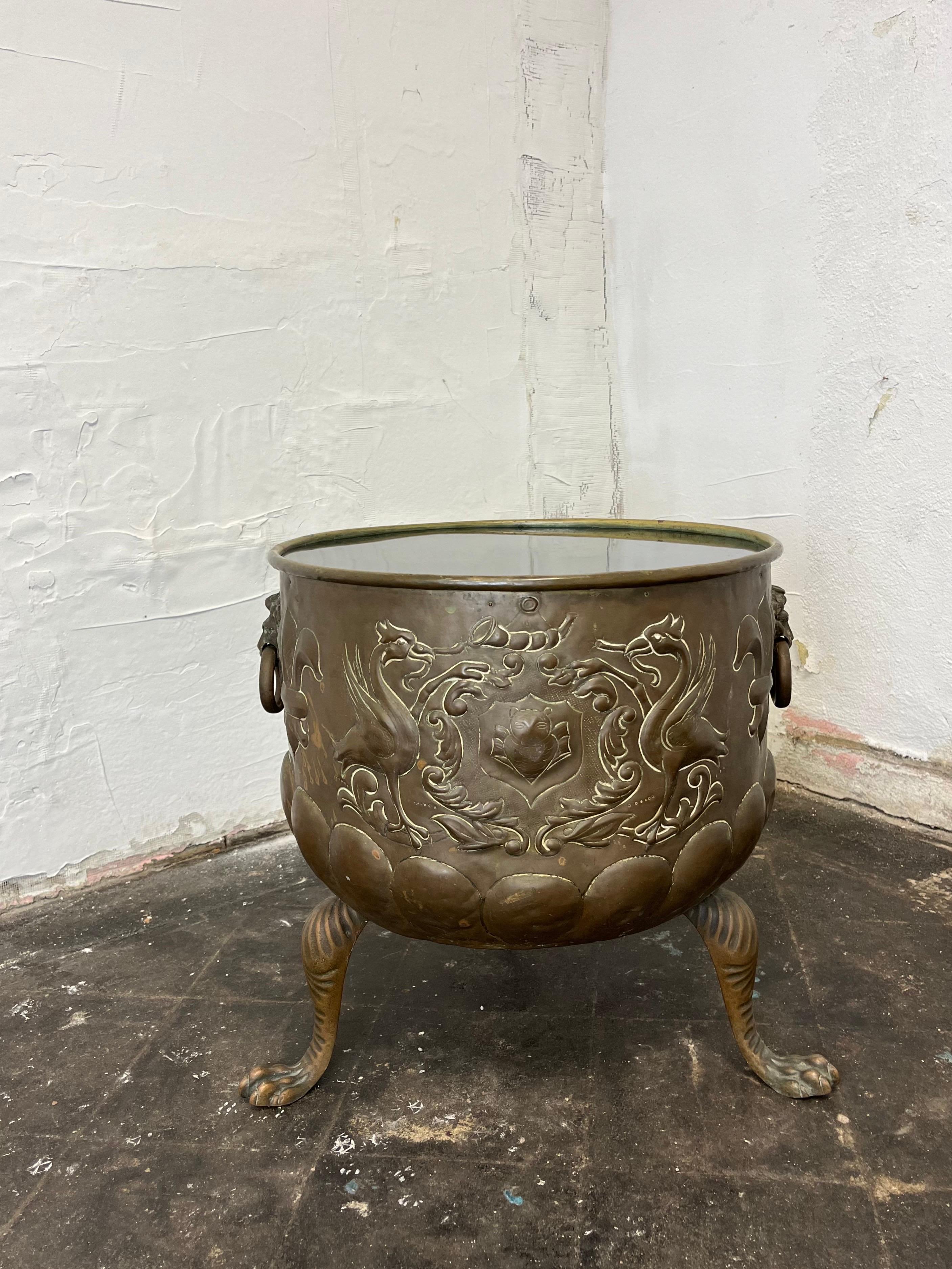 Ottimo tavolino su misura. Base per cachepot in ottone in stile Regency con splendidi dettagli di leoni, alloro, fleur-de-lis, uccelli e zampe di leone.  Il piano del tavolo in vetro nero è stato inserito nel top per garantire una grande