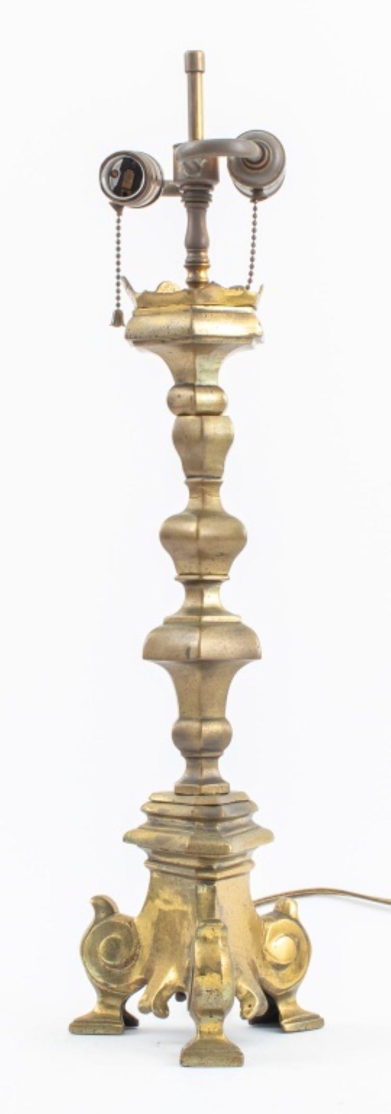 Polished brass church candle stick with triangular base and three legs mounted as a lamp.

Dealer: S138XX