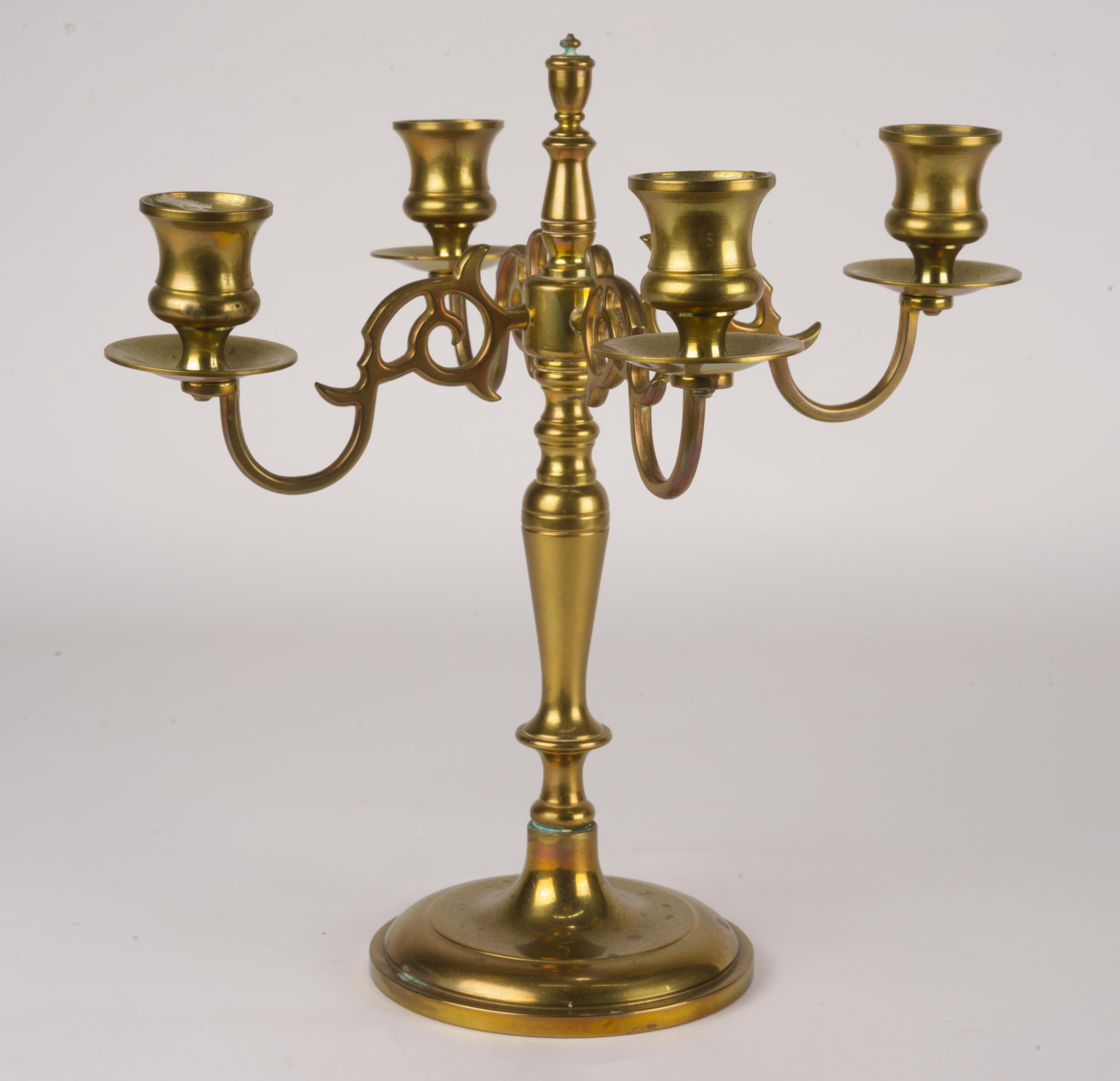  Vintage brass candelabra in continental or traditional style has 4 figurative arms and heavy, stable round base. Each candle holder is fitted with a bobeche to prevent wax drippage. Elegant finial echoes the shape of the stem.

The candelabra is