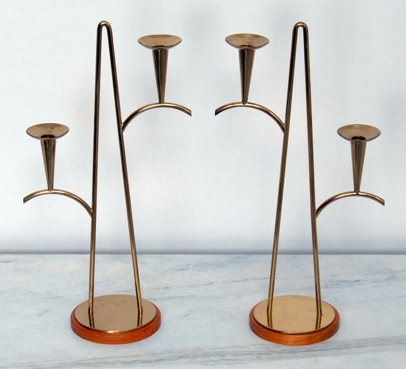 Pair of brass candleholders for smaller candles on wooden sockets. Designed by Gunnar Ander for Ystad Metall. Stamped ”Ystad Metall Made In Sweden” in sockets.
   