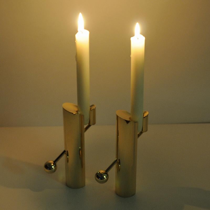 Very special and heavy midcentury candle light pair named “Variabel” made of solid brass by Pierre Forssell for Skultuna - Sweden 1960s. He designed these candleholders to make the whole candle visible when burning. The arm slides through the body