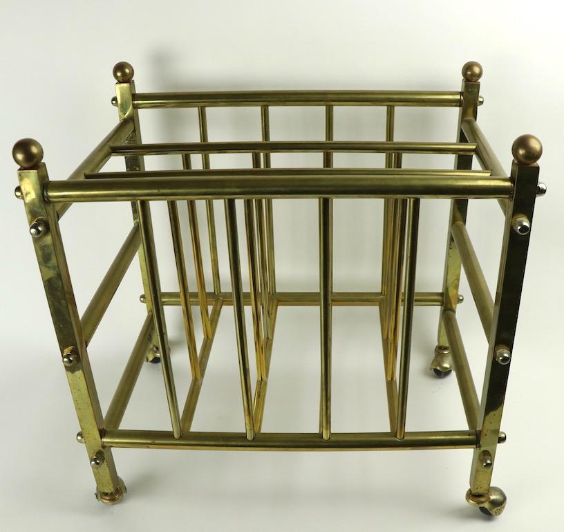 Chic brass Canterbury magazine rack, of squared and tubular brass construction with hooded ball coaster feet. Nice clean, original condition, ready to use.