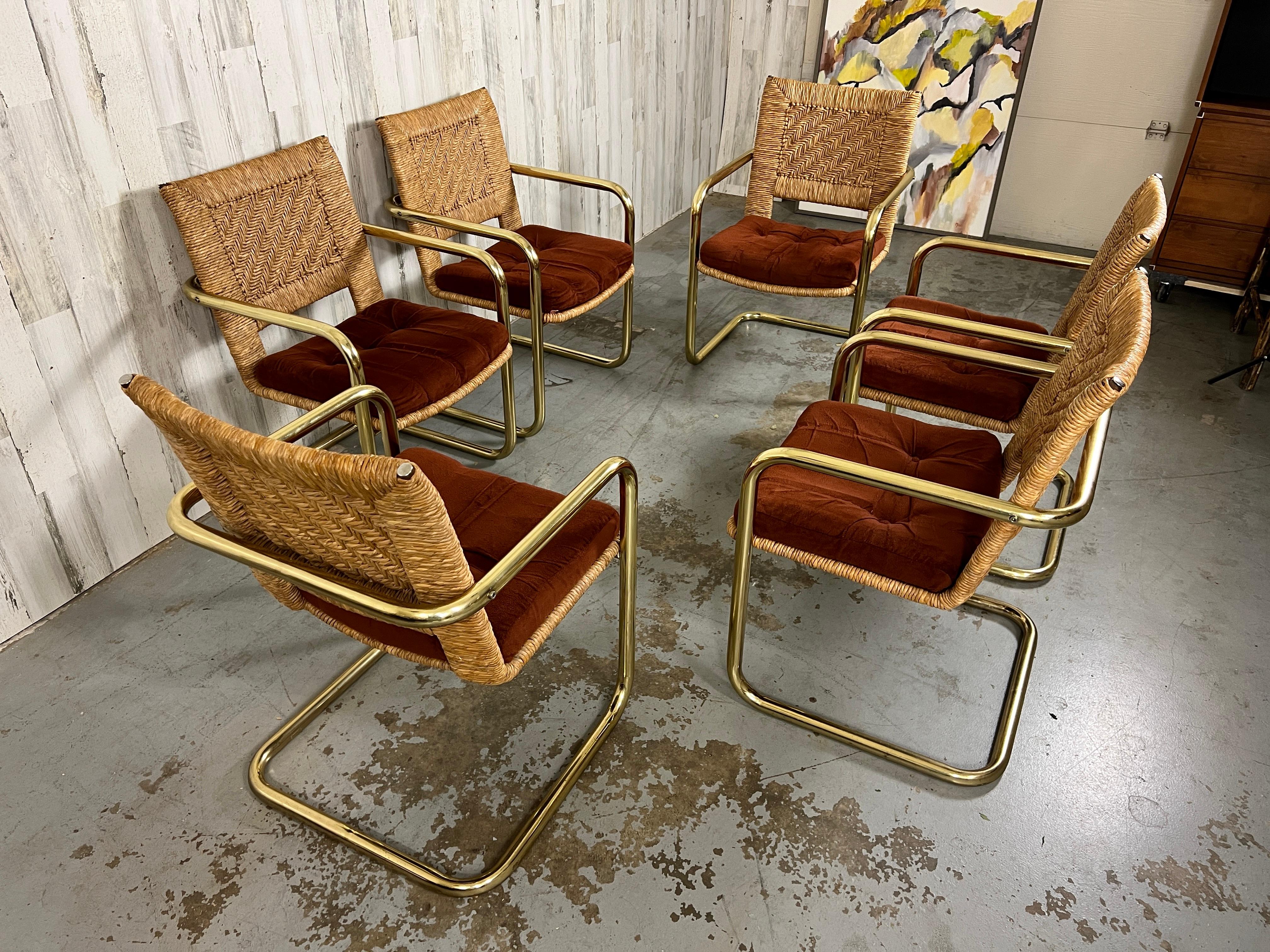 Set of 6 Cantilevered dining chairs with woven rush backs and upholstery covered seats by Chrome craft.
The rush back is woven in a geometric design that compliments the brass tube frame. The rush on the seat is only around the boarder of the