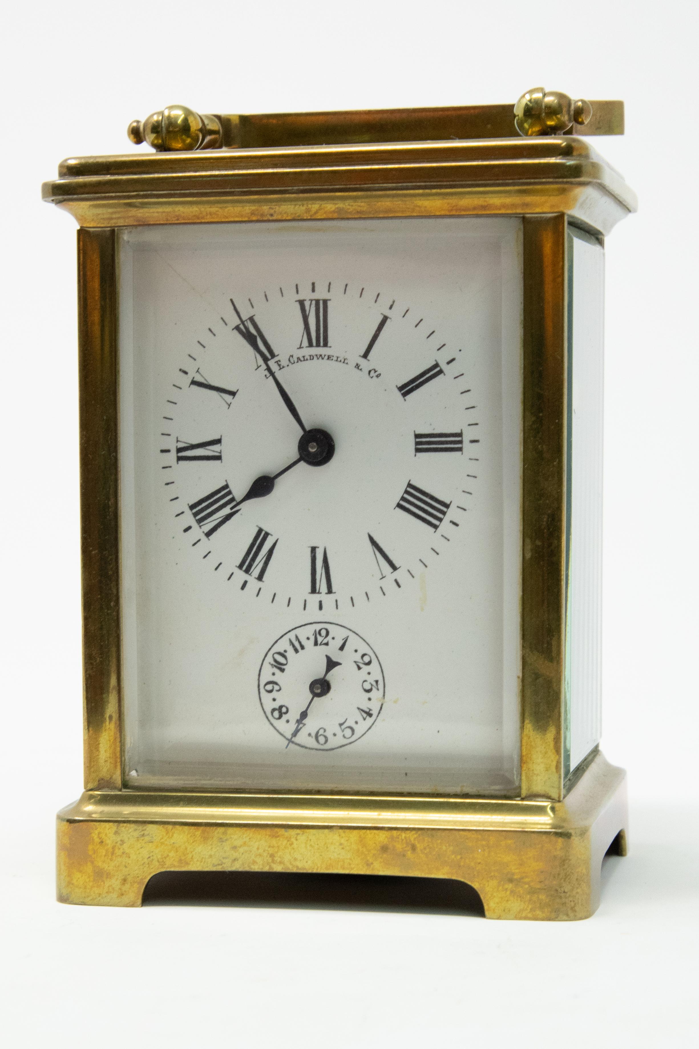 Offering this magnificent carriage clock by JE Caldwell & Co. stands on a bracketed foot with beveled glass all around. The clock face is simple black and white. The key is with the clock, it does wind up and work. Keeps time pretty accurately. Also
