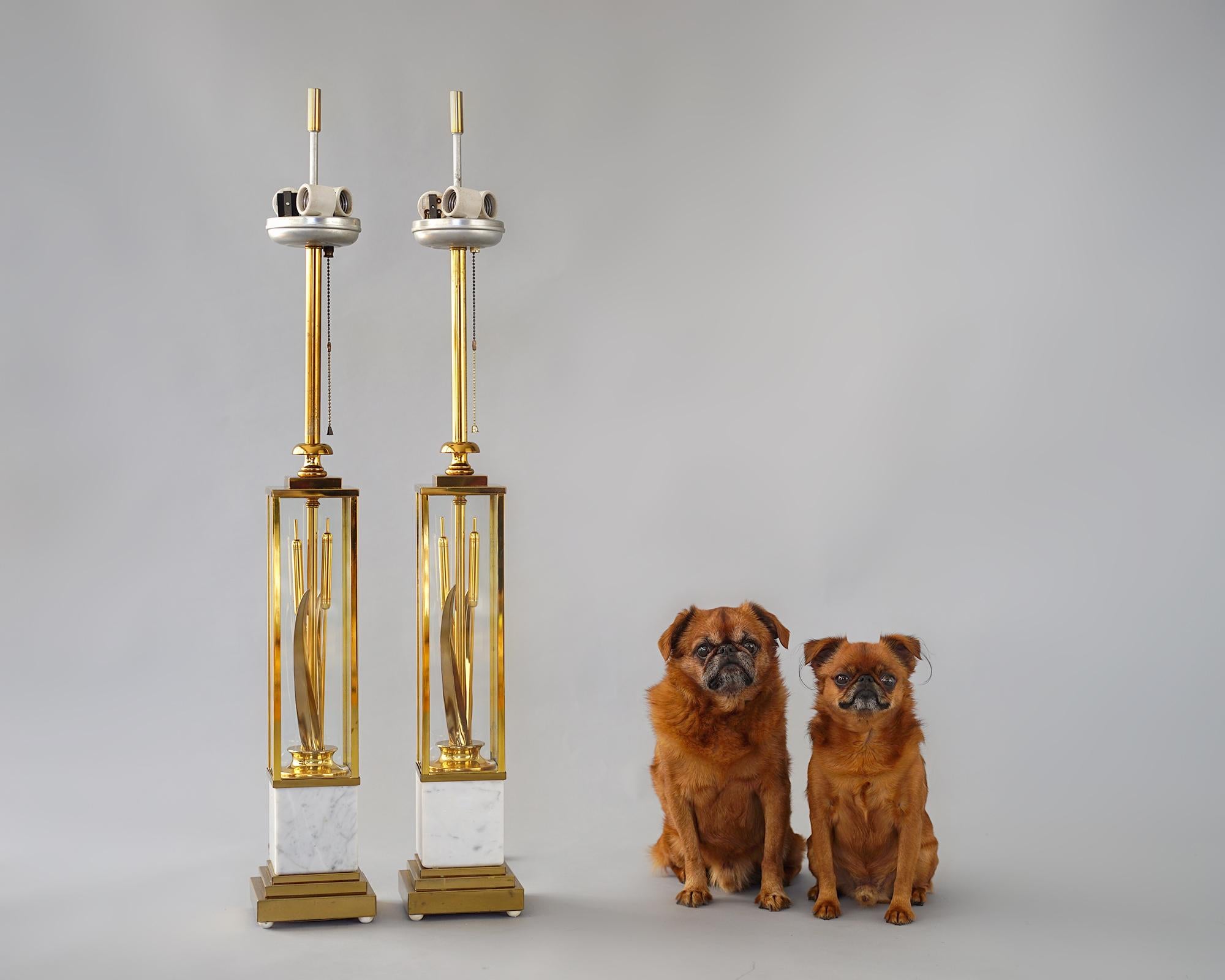 Modernist cattails sculptures encased in brass and glass vitrines. Original triple porcelain sockets with three-way pull chain switch. Elevated on Italian marble pedestals with brass ziggurat form bases and original white hemispherical feet.