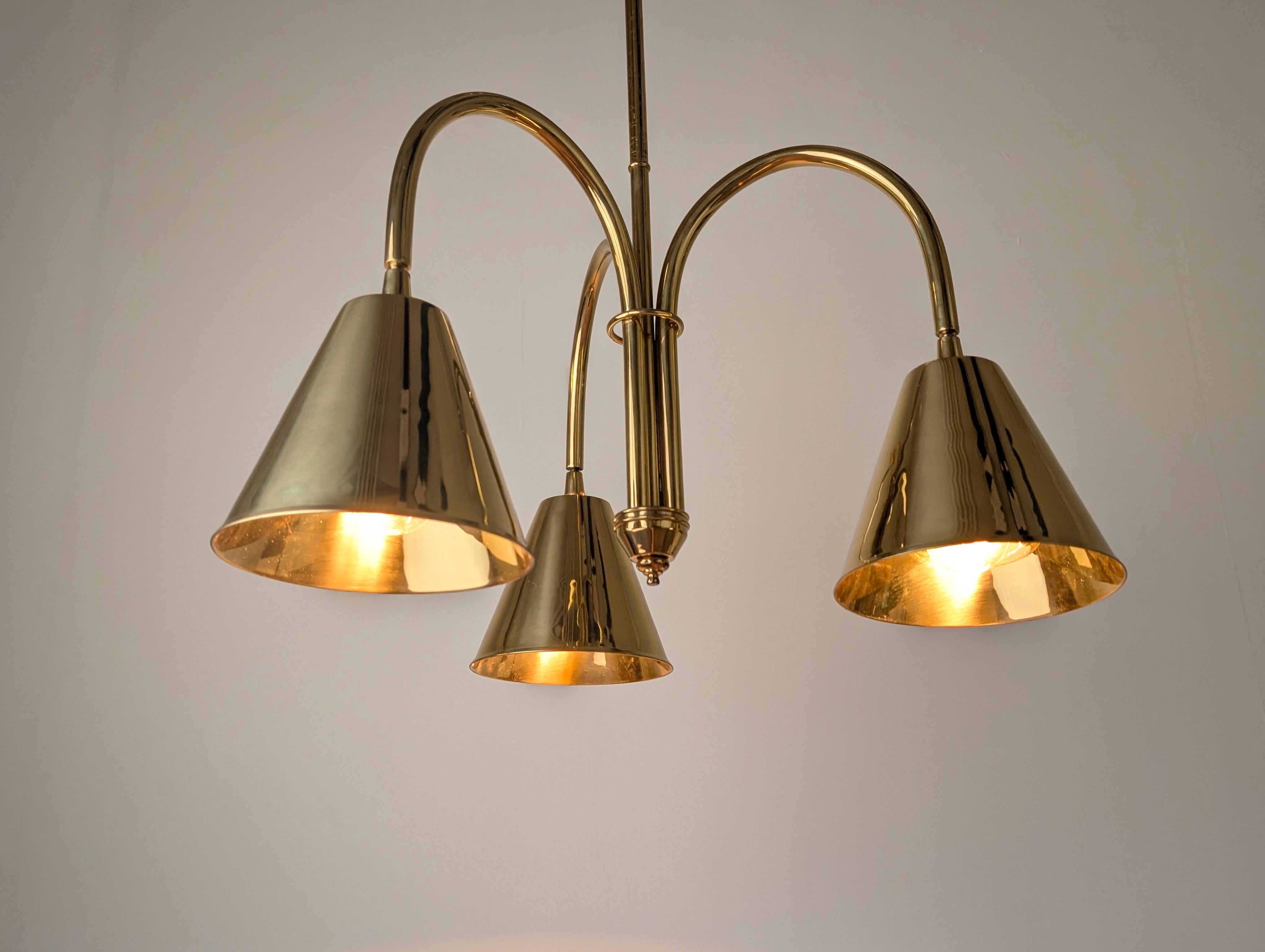Elegante lámpara de techo creada por Valenti en los años 70, ésta es una versión realmente exclusiva inspirada en los diseños de Jacques Adnet, que adapta su lenguaje visual a una pieza suspendida. La estructura, totalmente de latón macizo con