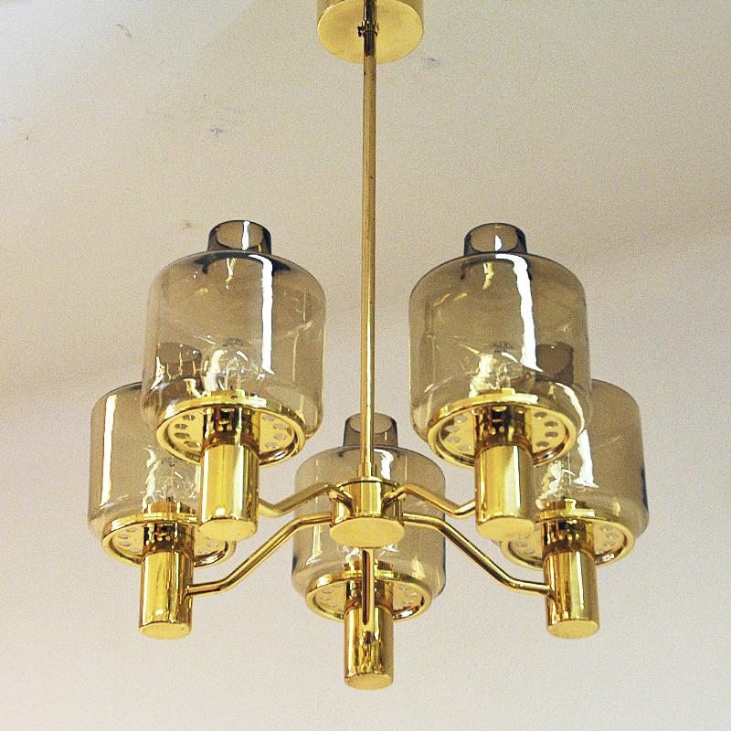 A beautiful 5-armed chandelier prior model T507 made of polished brass and smoke clear glass domes. This lovely lamp is designed by Hans-Agne Jakobsson in Markaryd, Sweden in the 1960s. Good vintage condition.
Size: 72 cm H, 51 cm D. Height of the