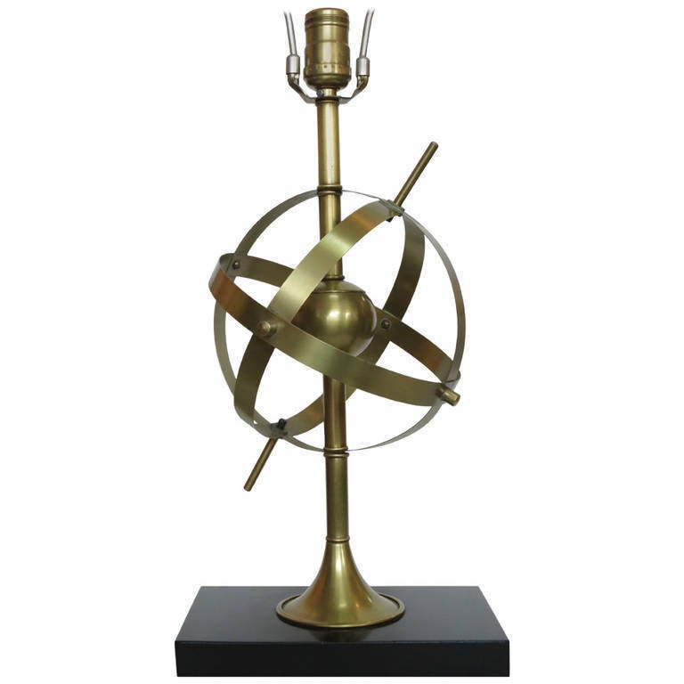 Made circa 1950, each Mid-century solid brass study lamp features an armillary globe as the centerpiece and is fixed to a black lacquered wood base.