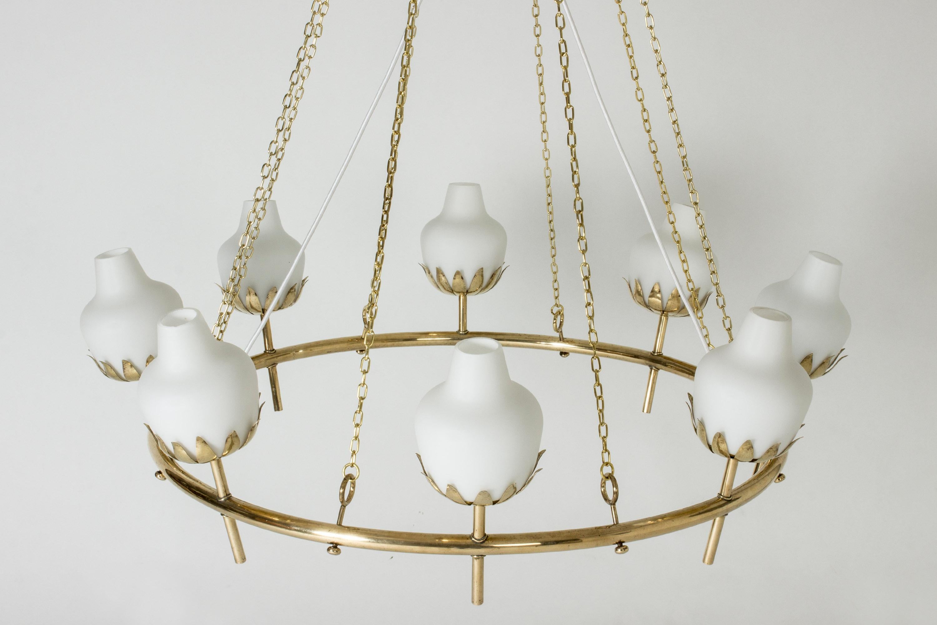 Stunning chandelier by Hans Bergström, made from a wide brass ring with eight lights. Opaline shades nestled in leaf holders with a hammered surface. Chains suspend the chandelier, the electrical cord runs elegantly through the middle. Decorative