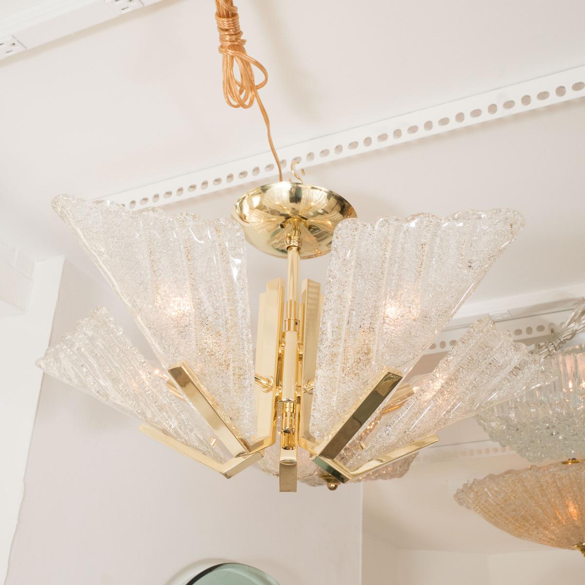 Brass chandelier featuring five textured glass shades.
