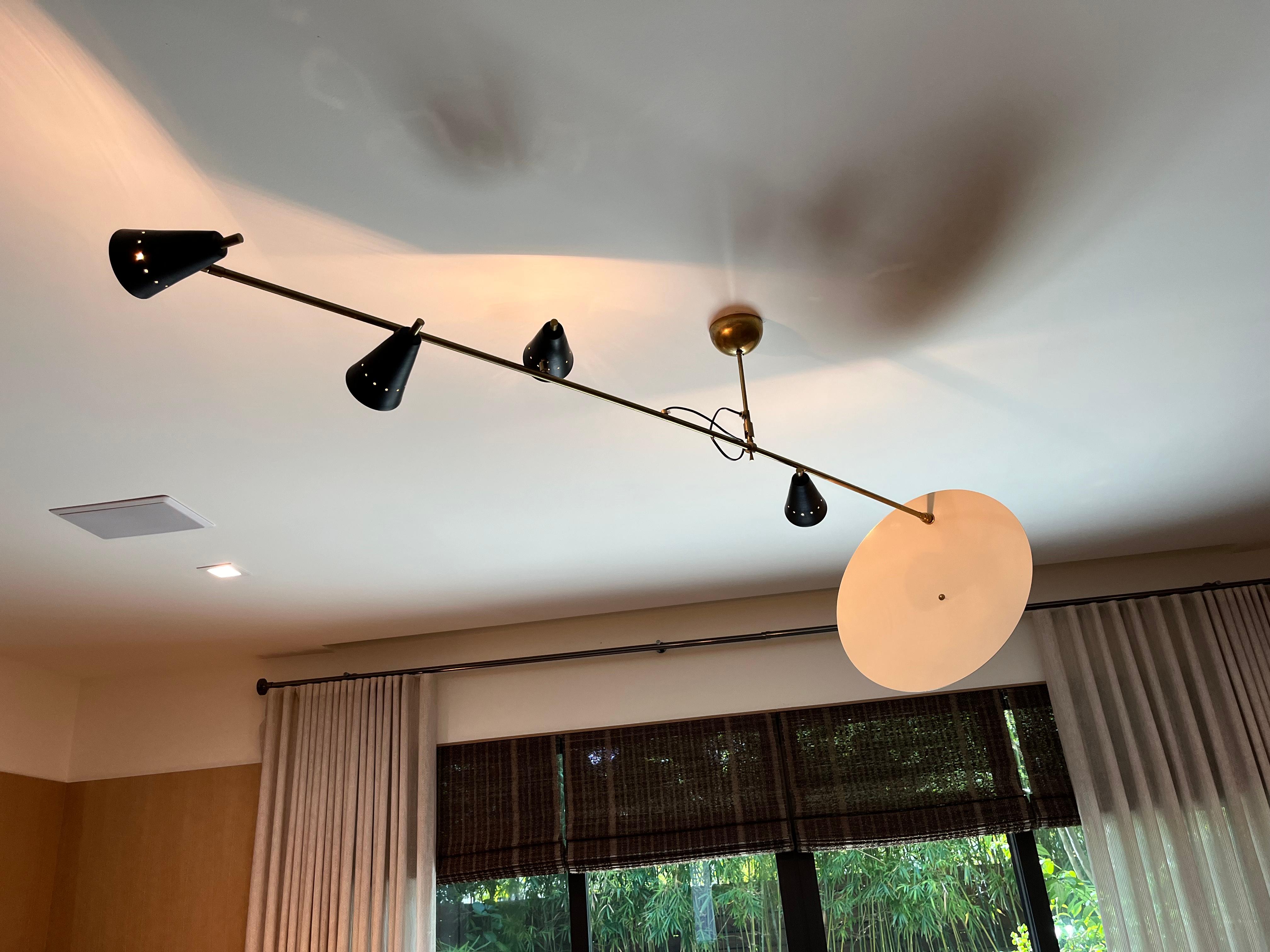 Sculptural ceiling light with multiple positions for light mobility. Each cone can be maneuvered as well as angled in the center of the hanging rod.