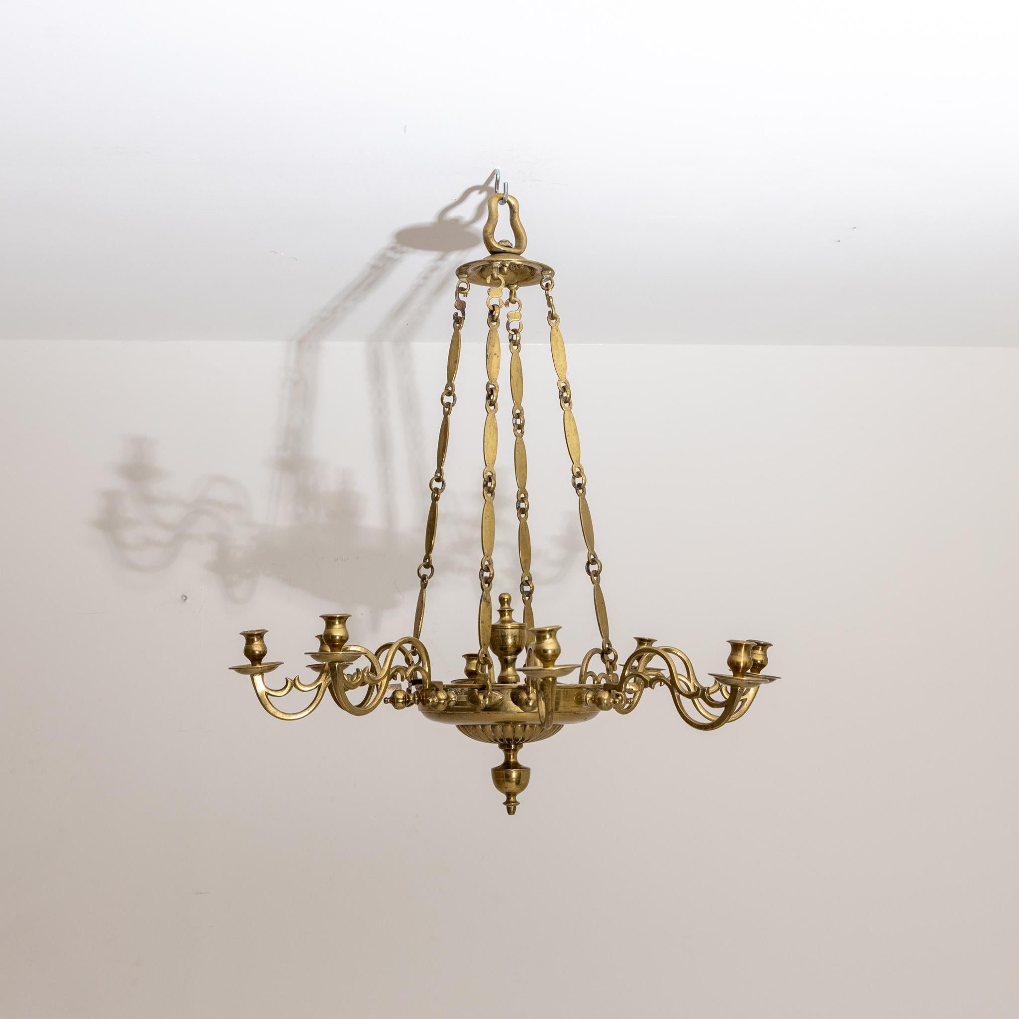 Large ceiling chandelier with eight arms and brass candle spouts.