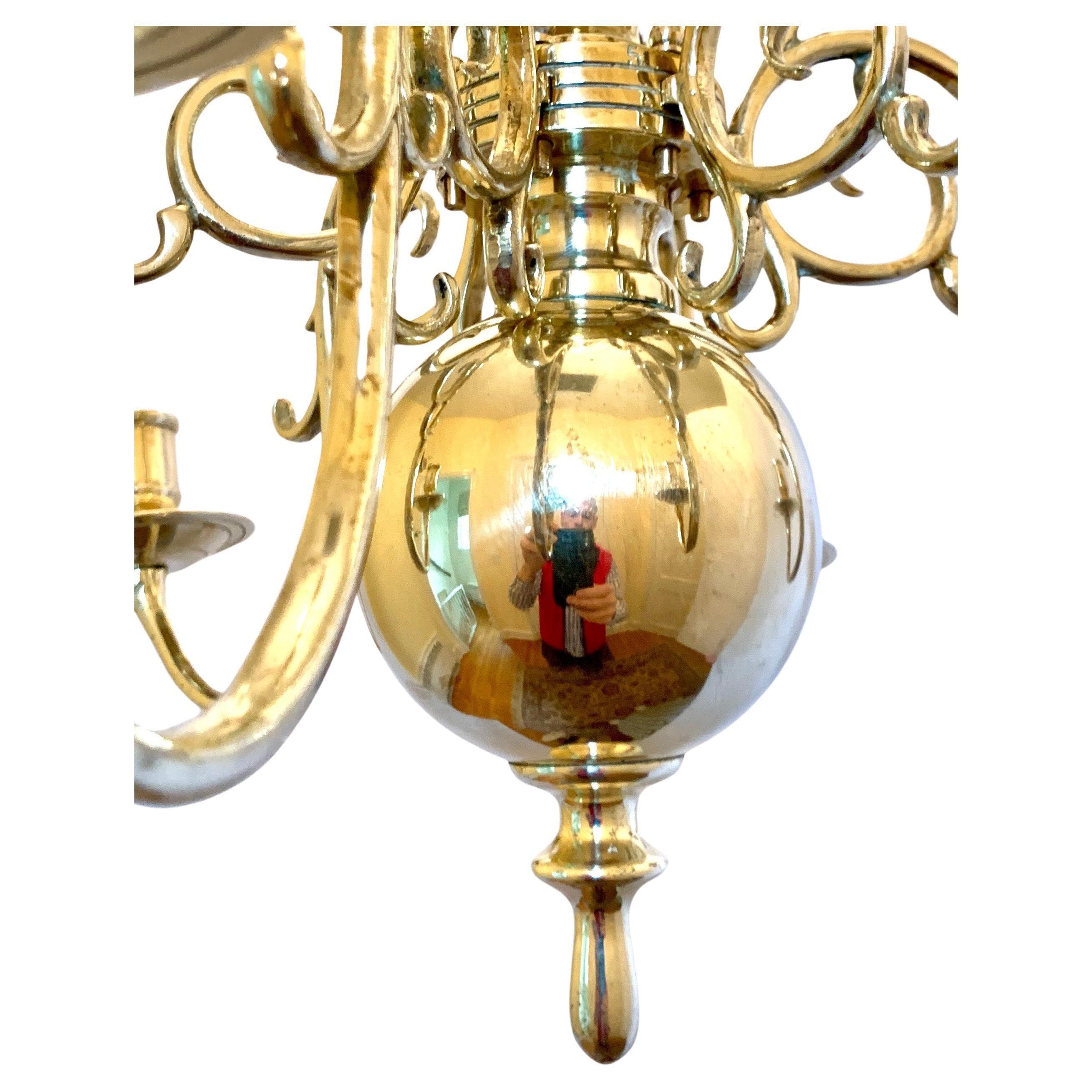 This Dutch brass six-arm chandelier was made in the 19th century.
It has scrolling mounted branches from a knopped column terminating in a large ball and ring at each end.
Deeply curved arms hold the candles at a level near the chandelier's