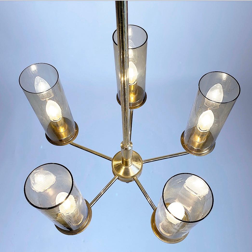 Beautiful Classic brass chandelier by Hans Agne Jakobsson, Markaryd, Sweden, 1960s.

Five-arm chandelier with each a hand blown smoked tube glass.

Each glass is 22.5cm high and has a diameter of 8.5cm.

The total height is 83.5cm with a