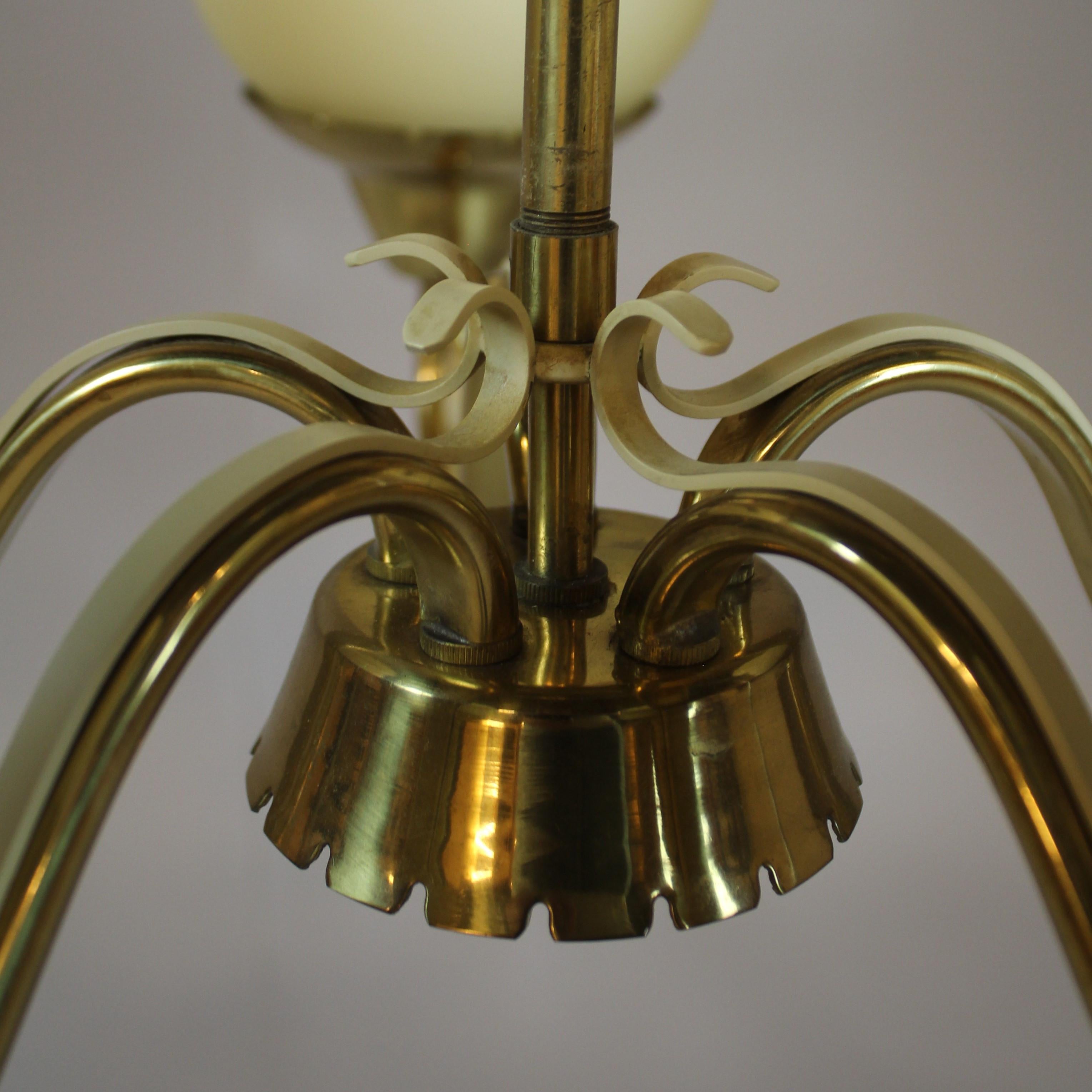 Brass construction with five opaline glass globes fitted with five E27 bulbs.
Designed by Bent Karlby for Lyfa in the 1950s in Denmark.
 