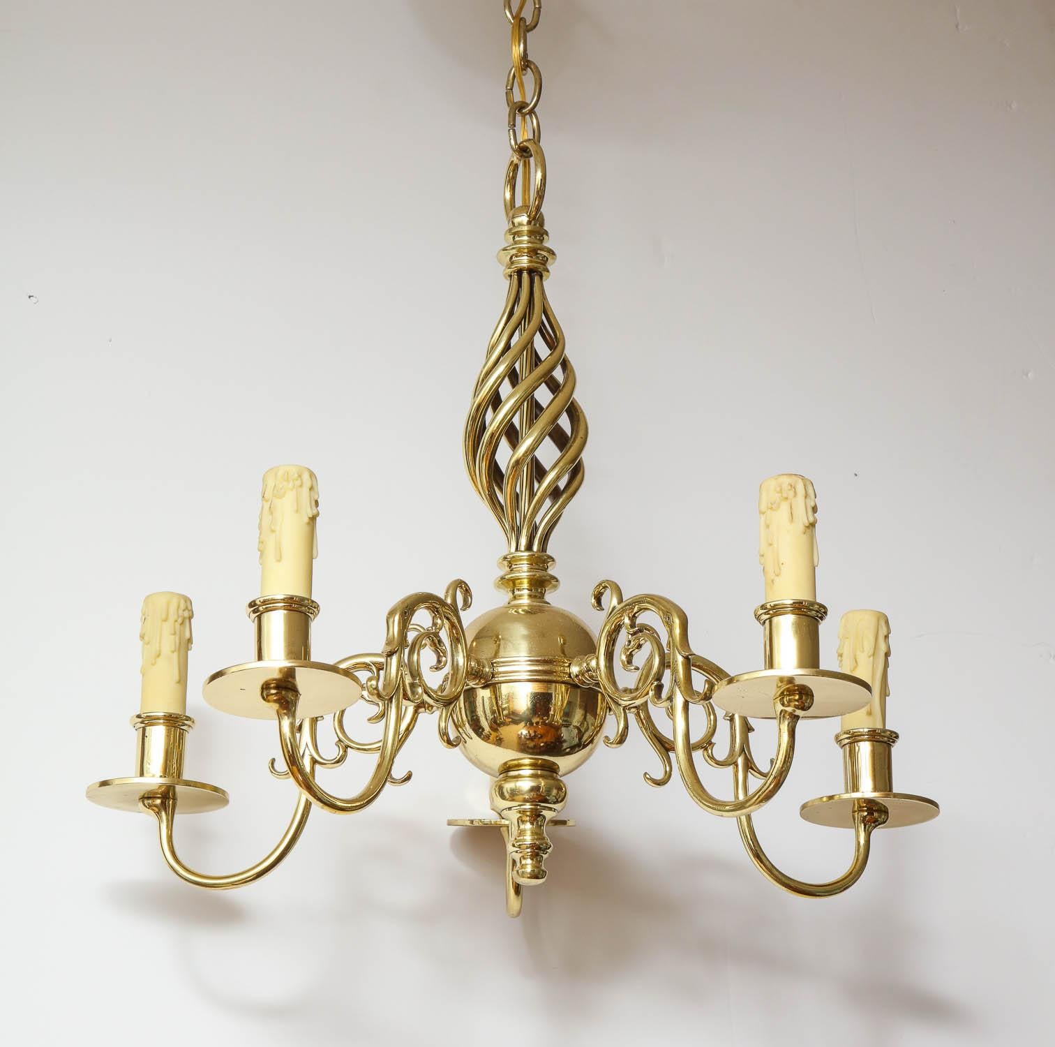 Fine 1930s brass five-light chandelier with open spiral fluted shaft over ringed ball, the five scrolled arms with cylindrical candle sockets and disc drip pans, recently rewired and polished.