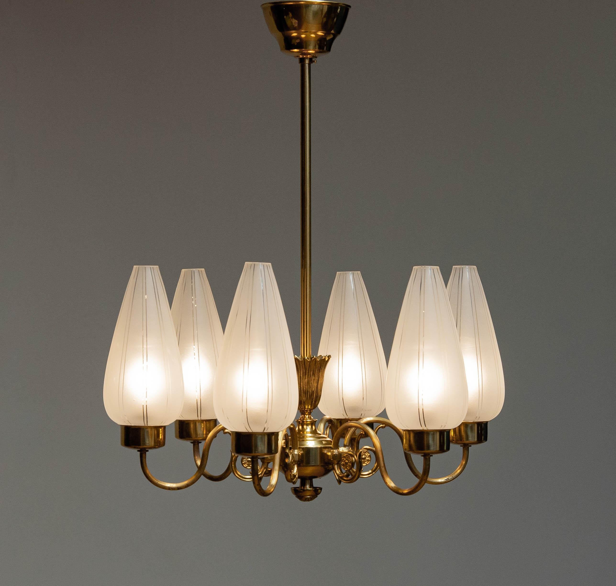 Lustre néoclassique en laiton, Suède, années 1940. Six bras supportant chacun un vase en verre d'art dépoli d'une hauteur de 20 cm. 
Le lustre est en très bon état et les six vases ainsi que le luminaire en laiton sont dans leur état d'origine
Six
