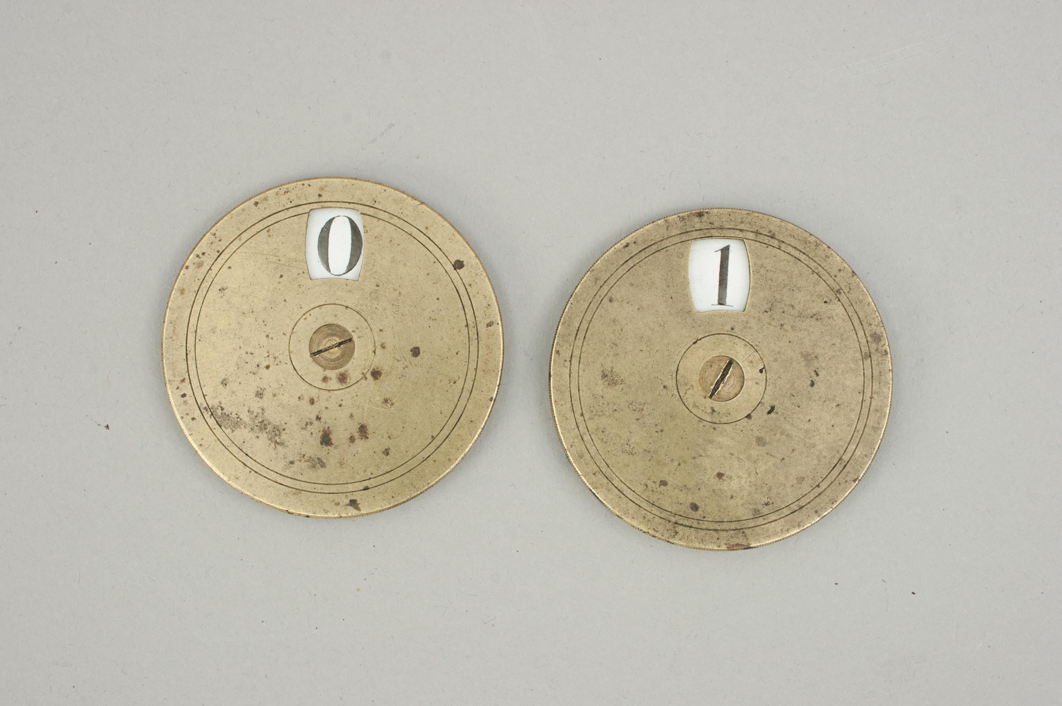 Messing Spielstand Zähler.
Ein Paar viktorianischer Whist-Spielstandanzeiger aus Messing und Rotguss. Die Oberseite des runden Zählers dreht sich, um die Punktzahl (0 bis 9) im Fenster anzuzeigen. Die schwarzen Zahlen stehen auf einem weiß