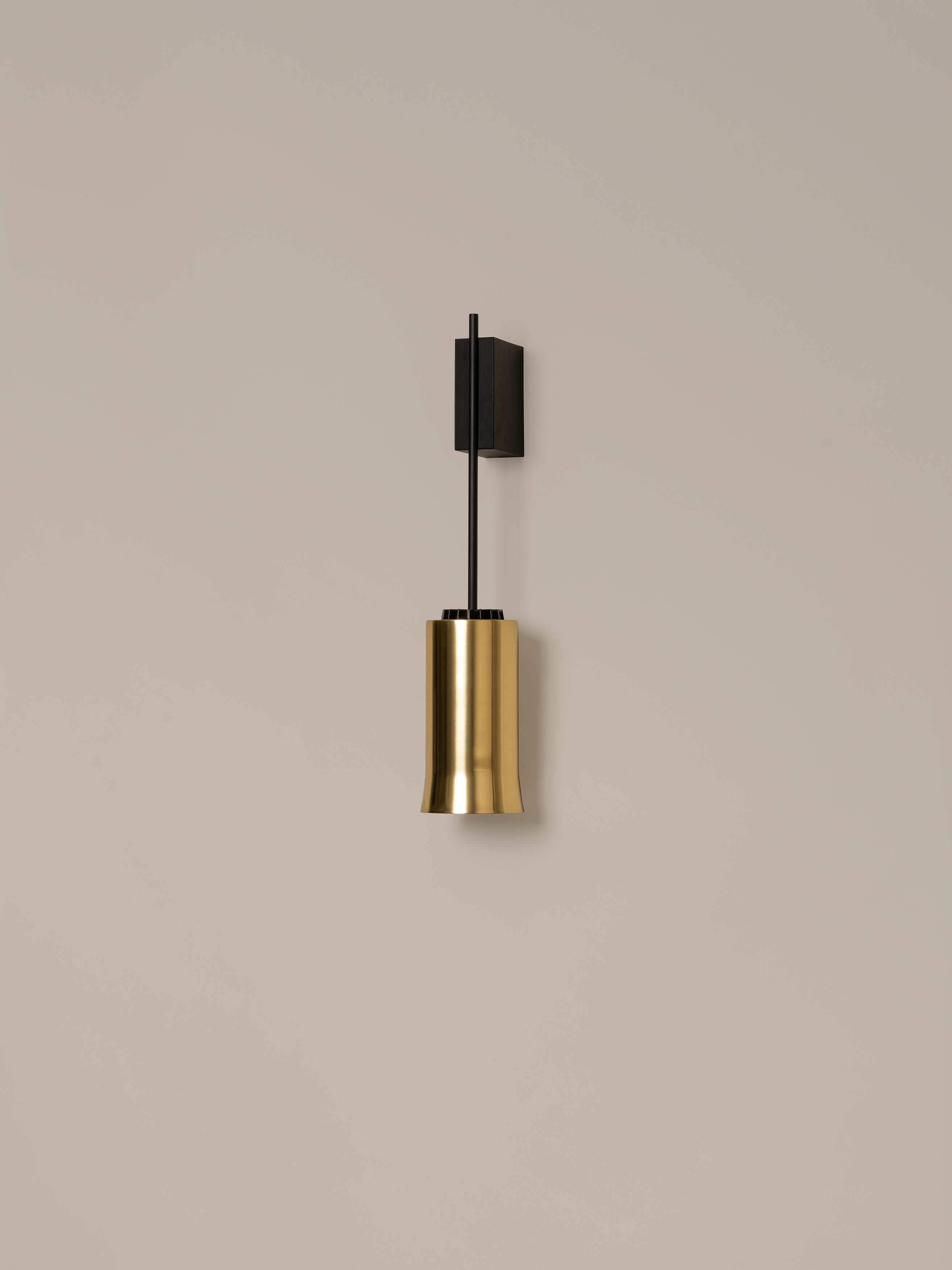 Brass cirio wall lamp by Antoni Arola
Dimensions: D 11 x W 14 x H 54 cm
Materials: Metal, polished brass.

The wall version of Cirio allows the light to be placed at a closer scale to the user. This creates a succession of rhythms that, in